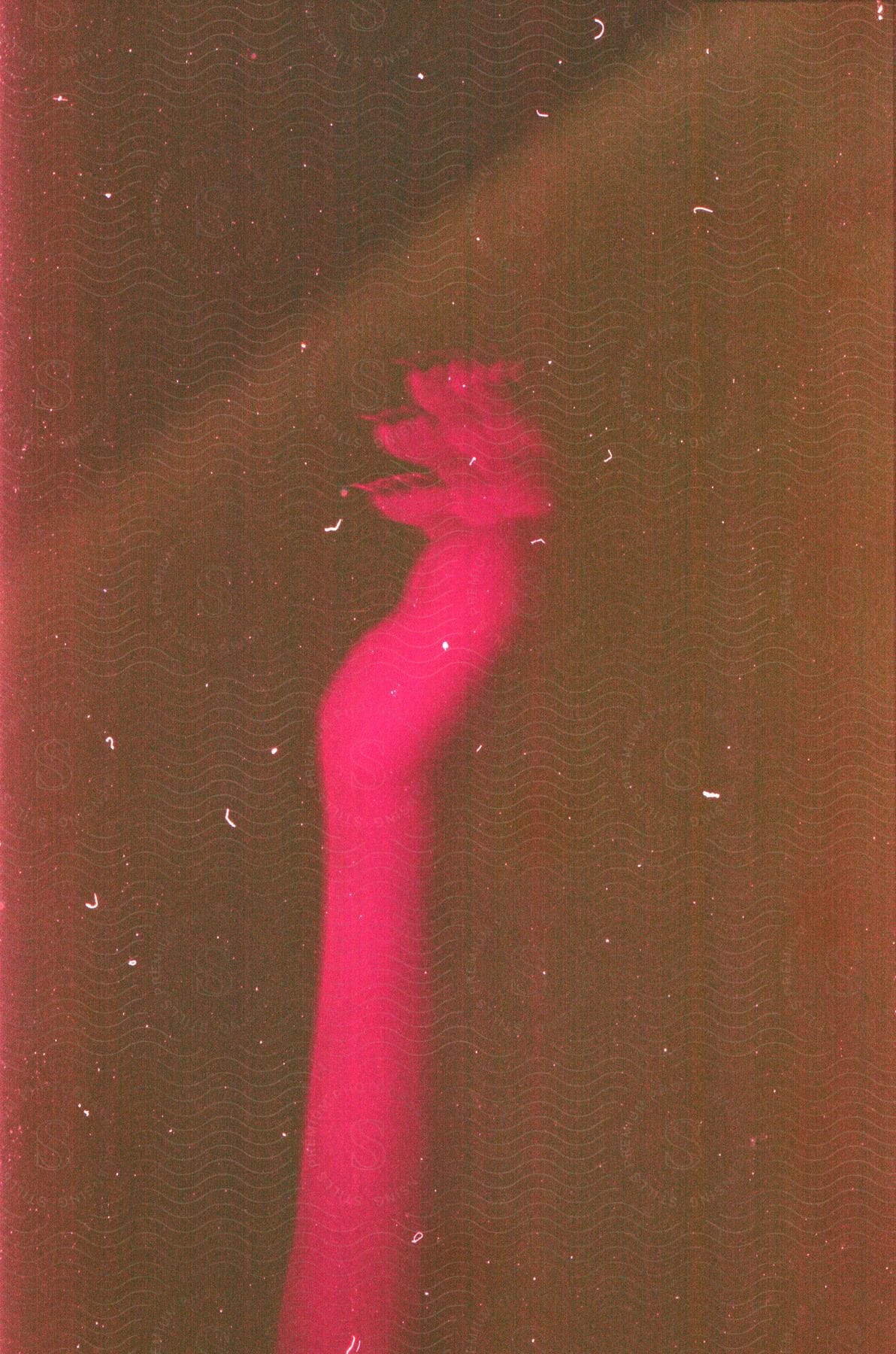 Female hand gesturing under strong pink light