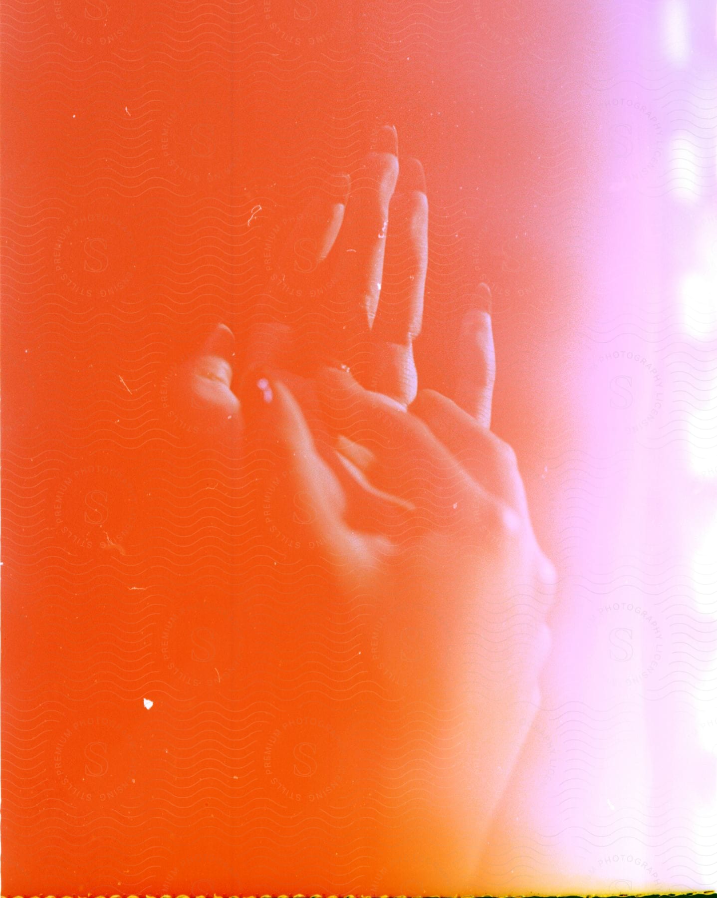 Close up of a young womans hands under red lights overexposed