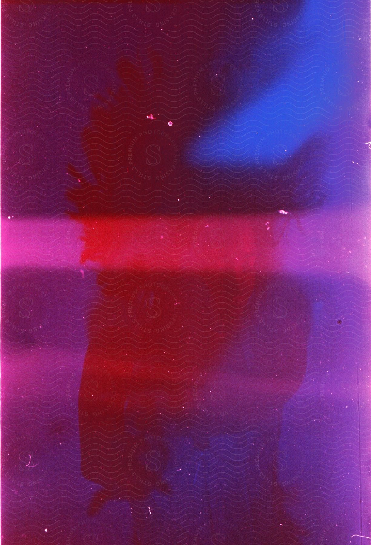 Multiple exposure shot of a woman posing under blue and red lights