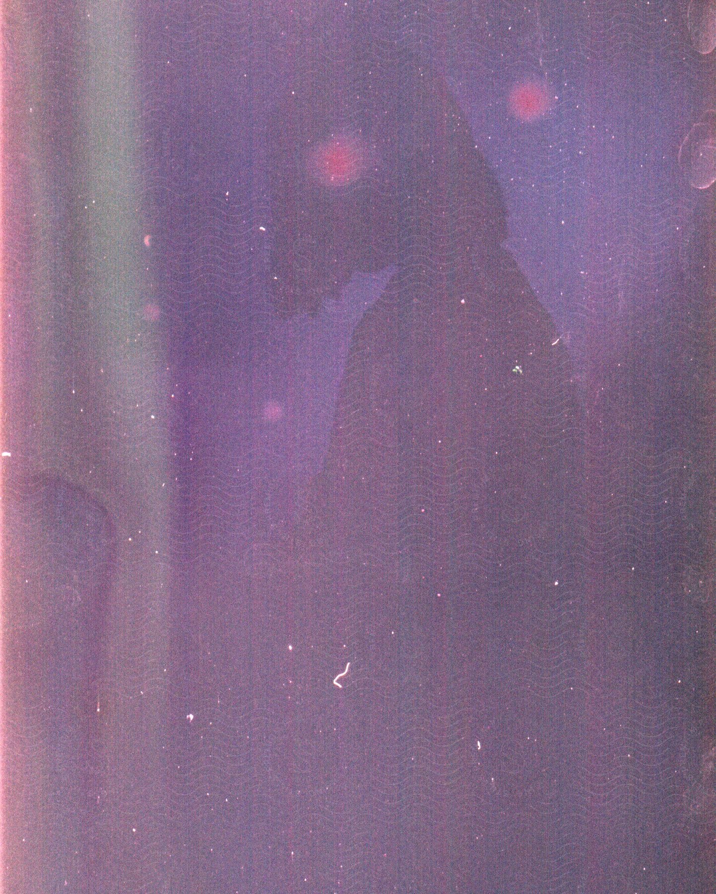 A person in a dark purple room at night