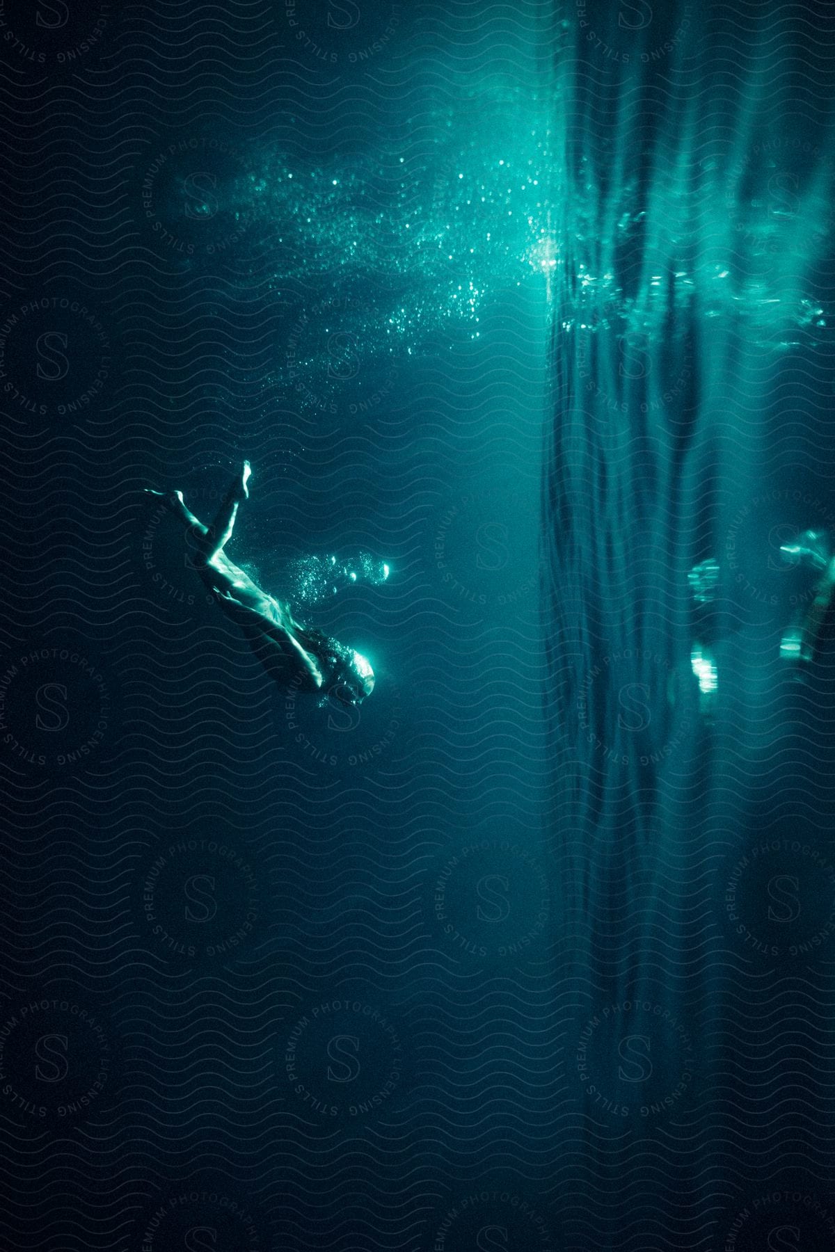 A woman swimming underwater in a pool