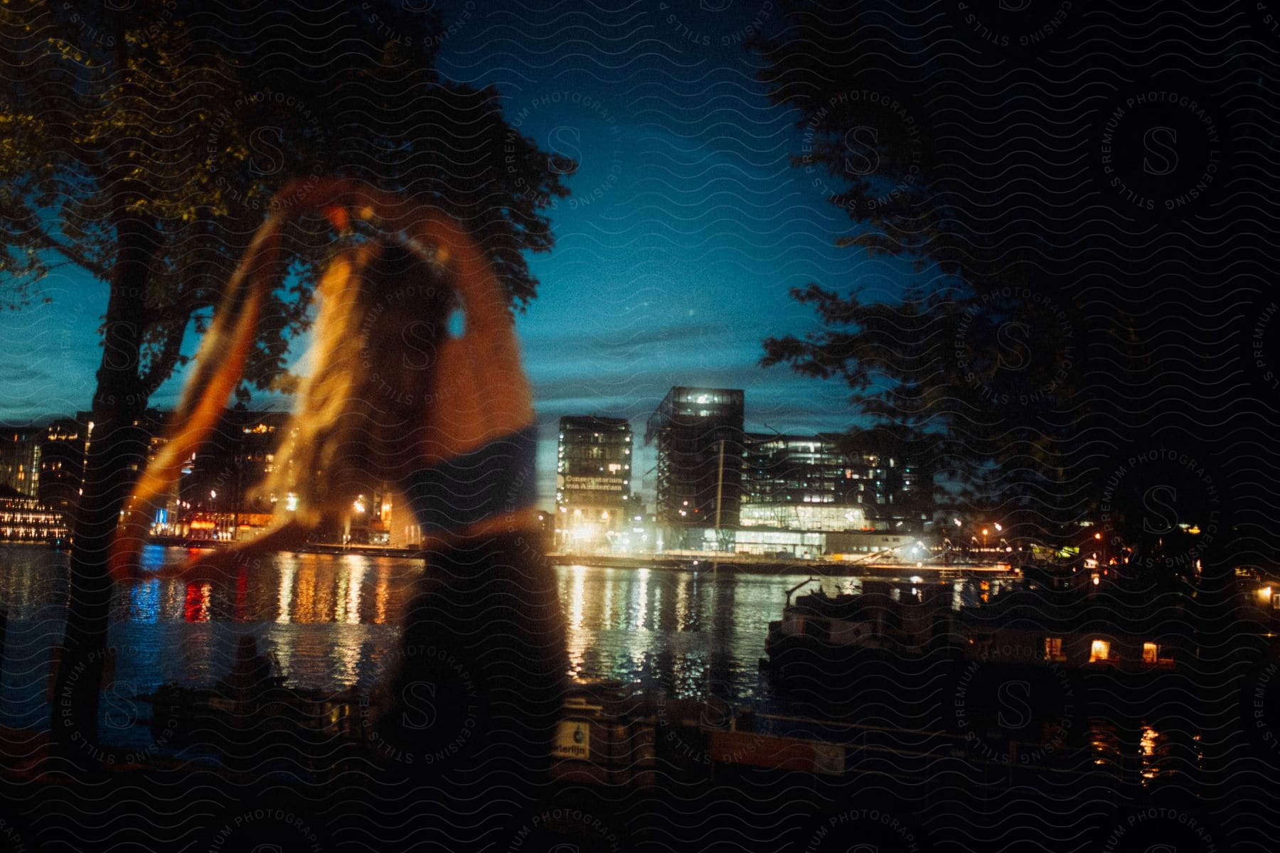 A happy woman in an urban cityscape at night excited by the waterfront scenery