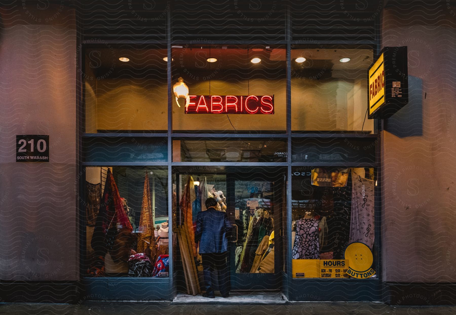 Man walking into a clothing store with neon sign glowing overhead in chicago