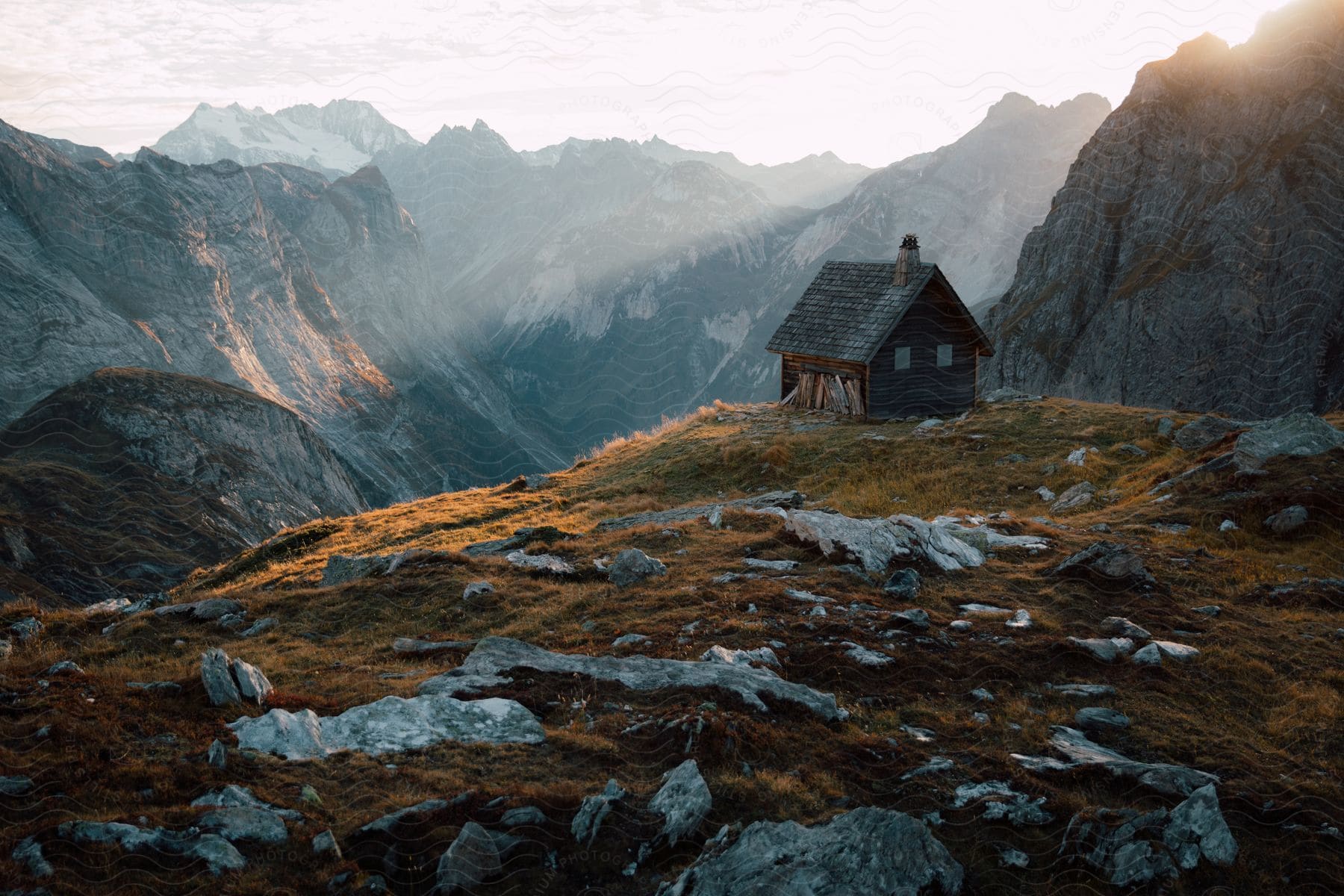 Sunlight shines over a cabin built in the mountains