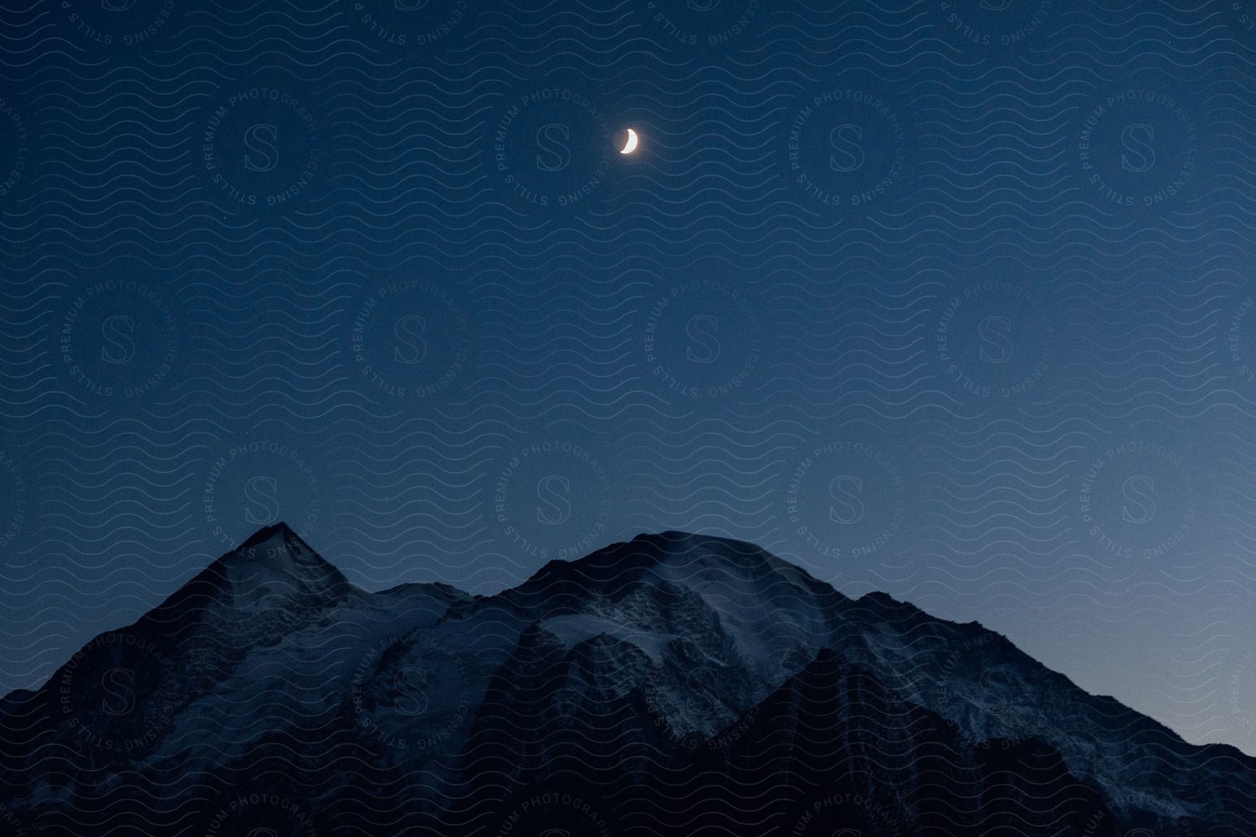 A moonlit sky over the majestic peaks of the alps at night