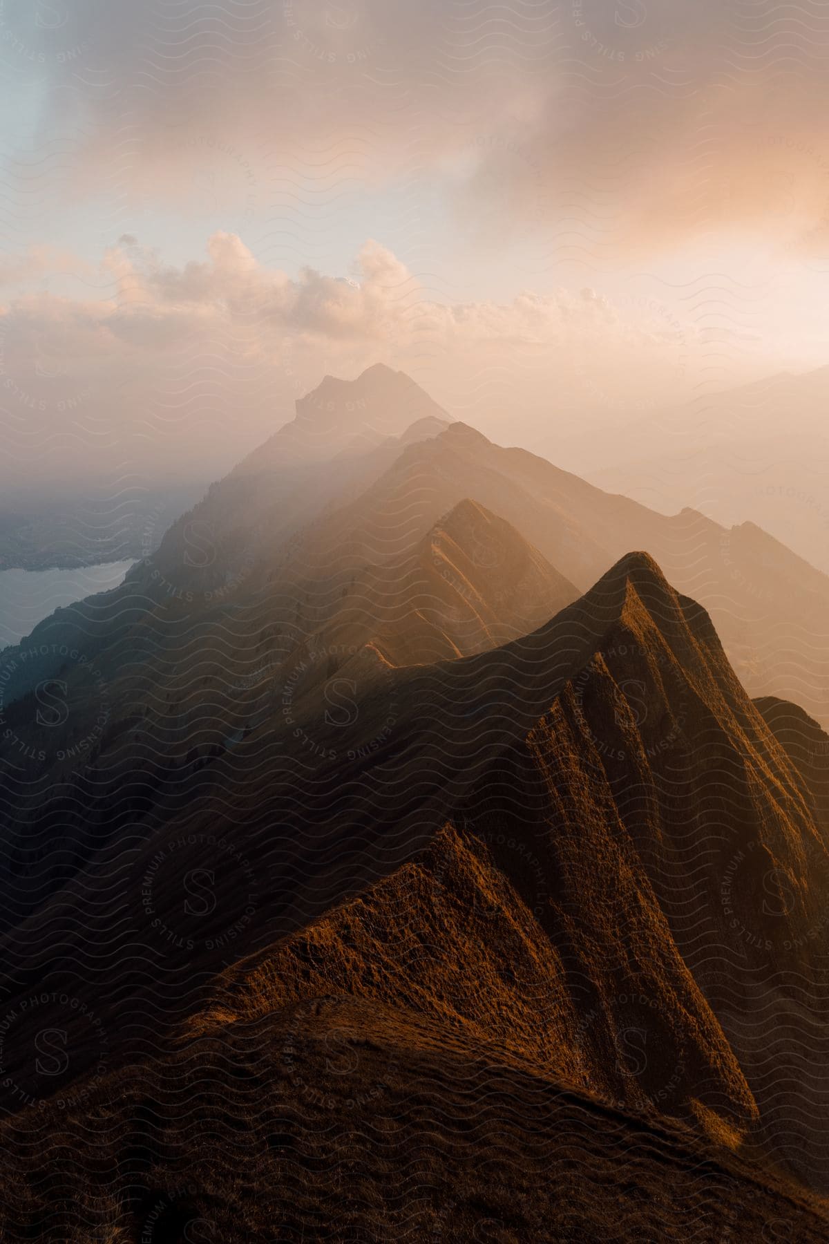 Mountains standing tall in a hazy sky illuminated by the sun