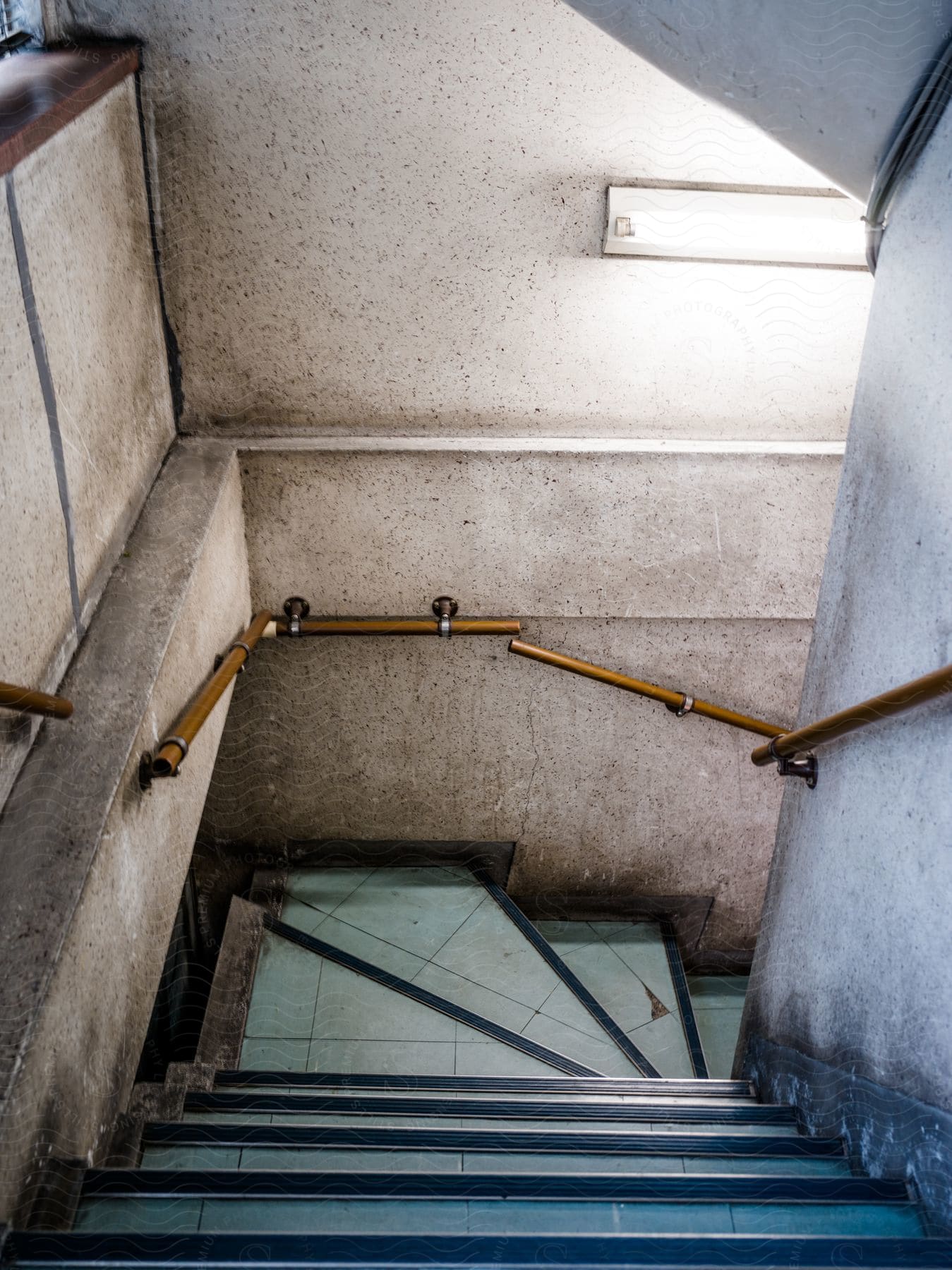 Interior of a building with stairs and yellow railing on a gray stop