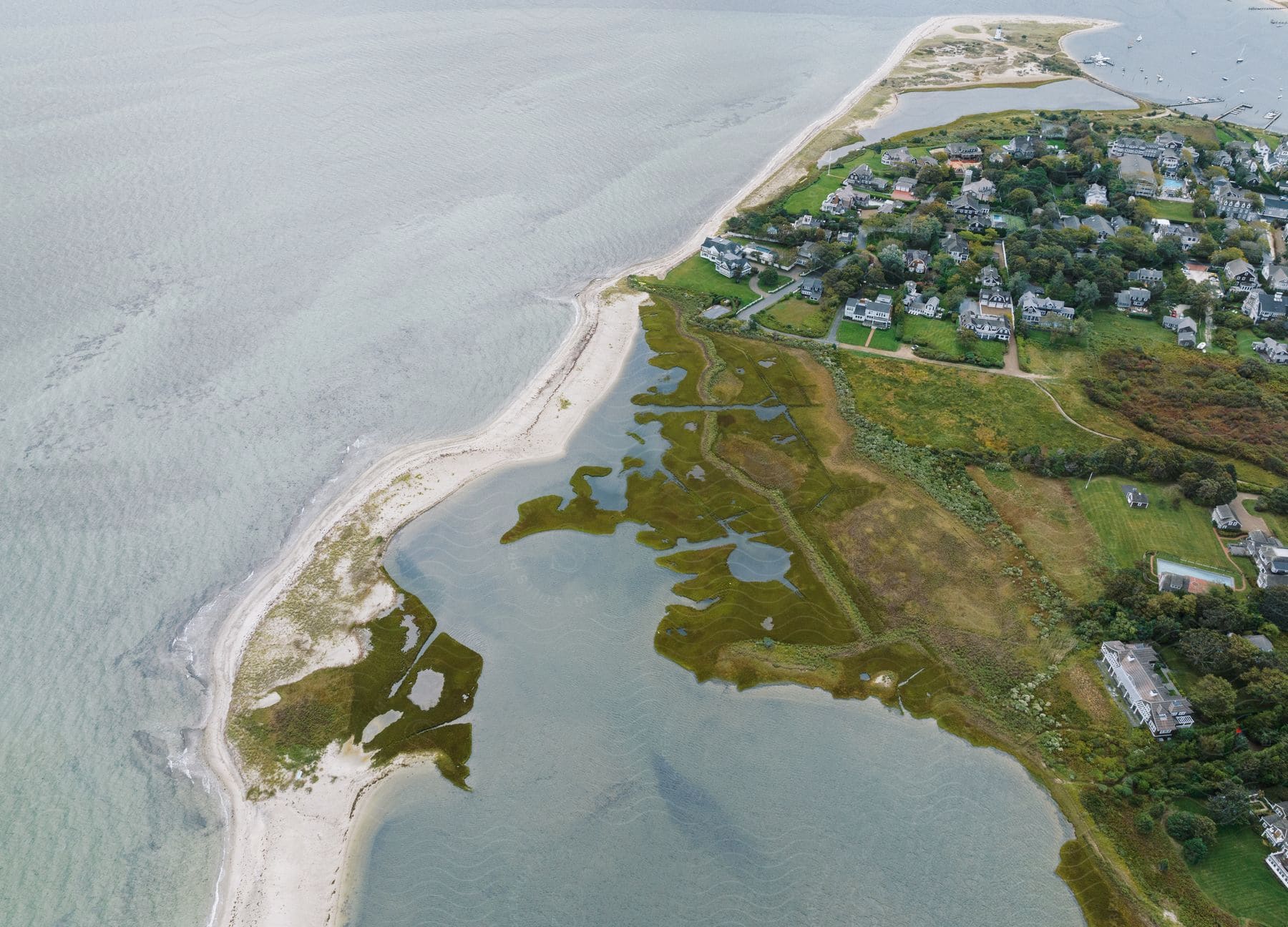 Aerial shot of a coastal island with small houses and flat land