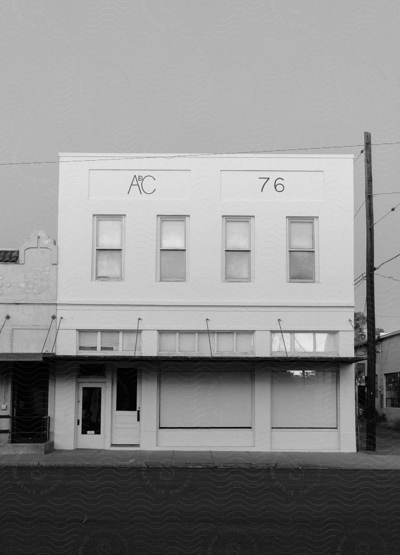 A white twostory building with two front doors on a smalltown street