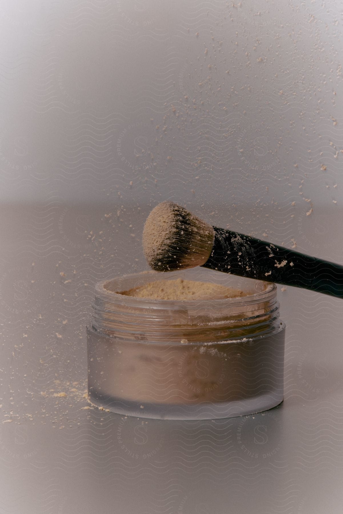 Stock photo of close up of a makeup brush dusting face makeup in a studio