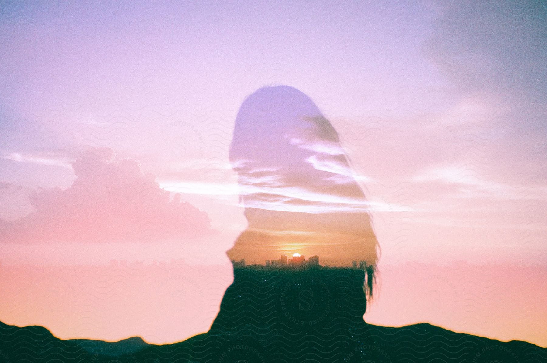 A persons silhouette is superimposed on a sunset horizon