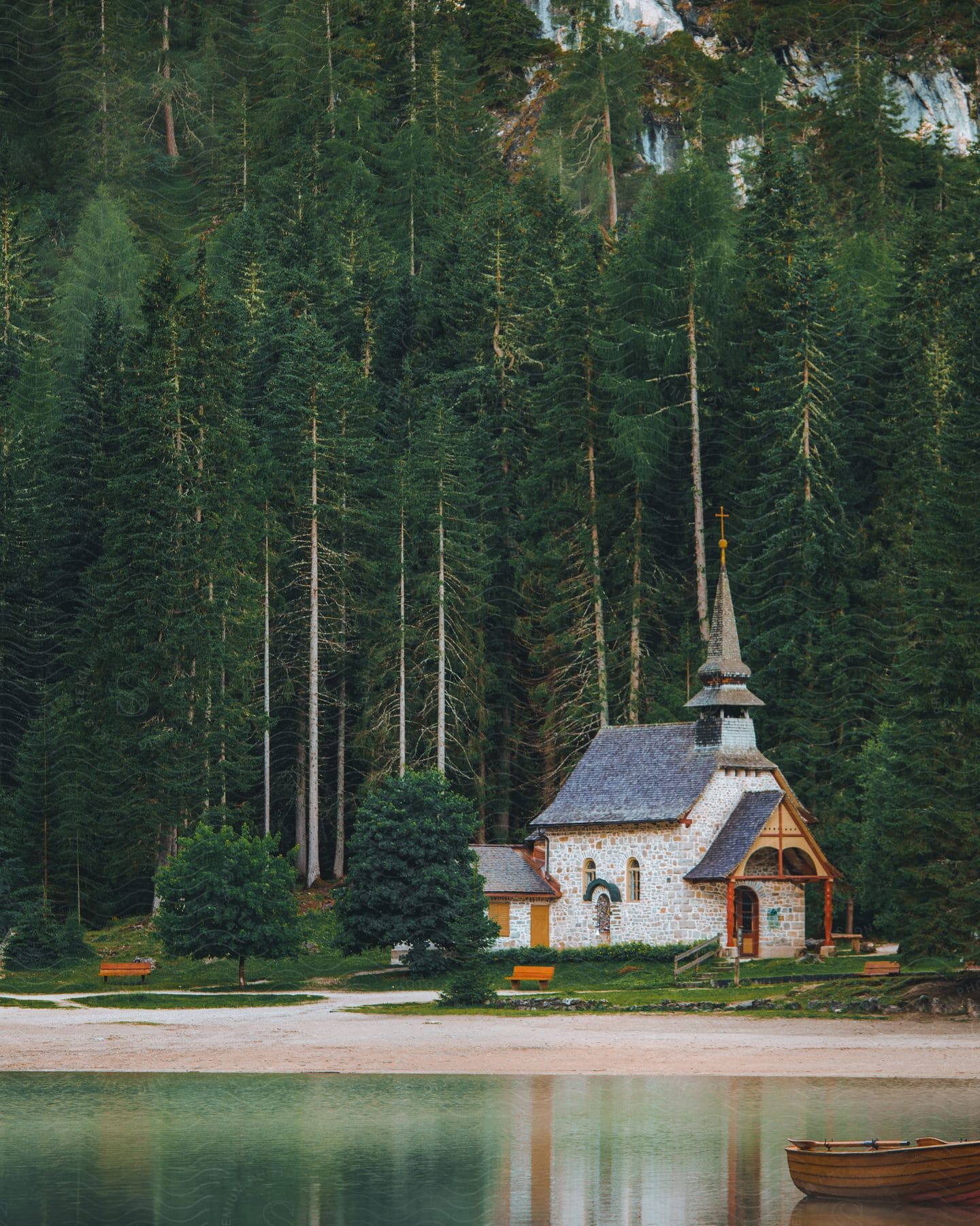 A chapel surrounded by trees along a lake