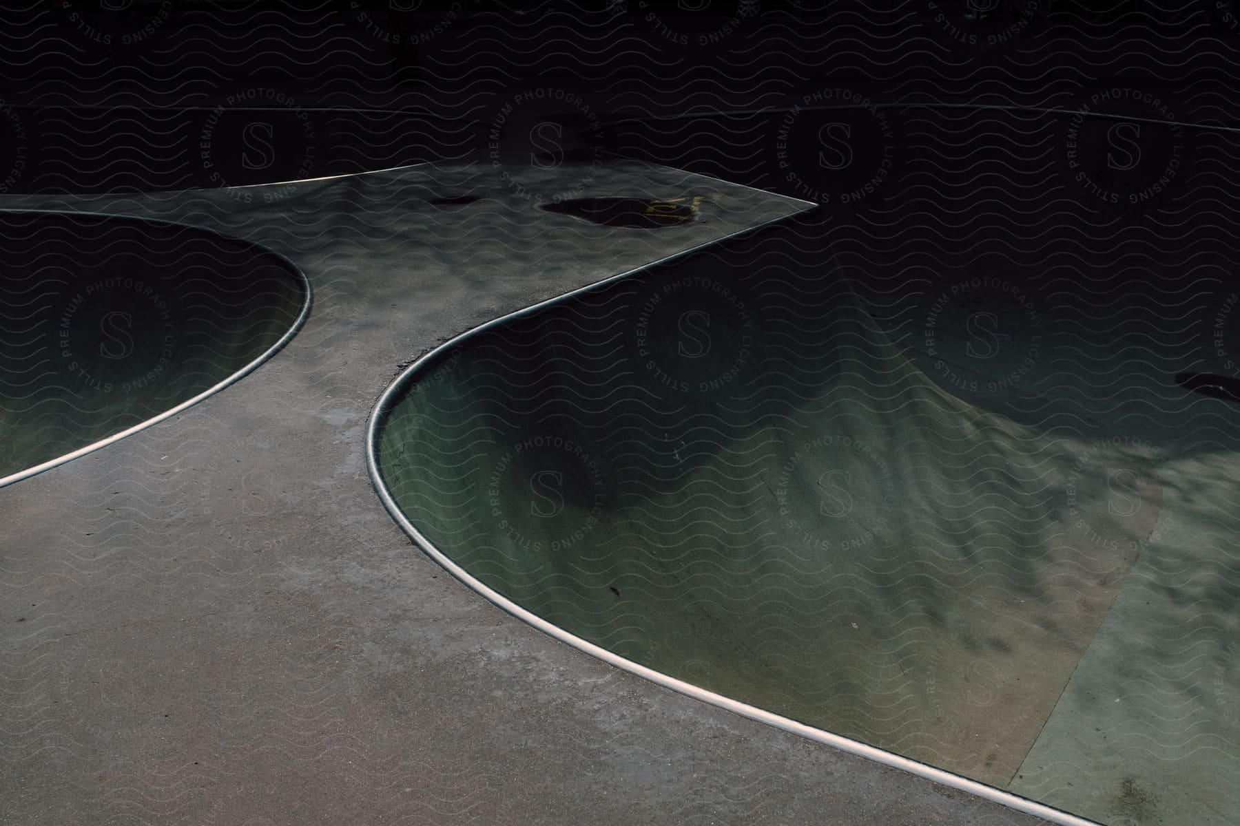 Empty skateboard ramp on an asphalt surface