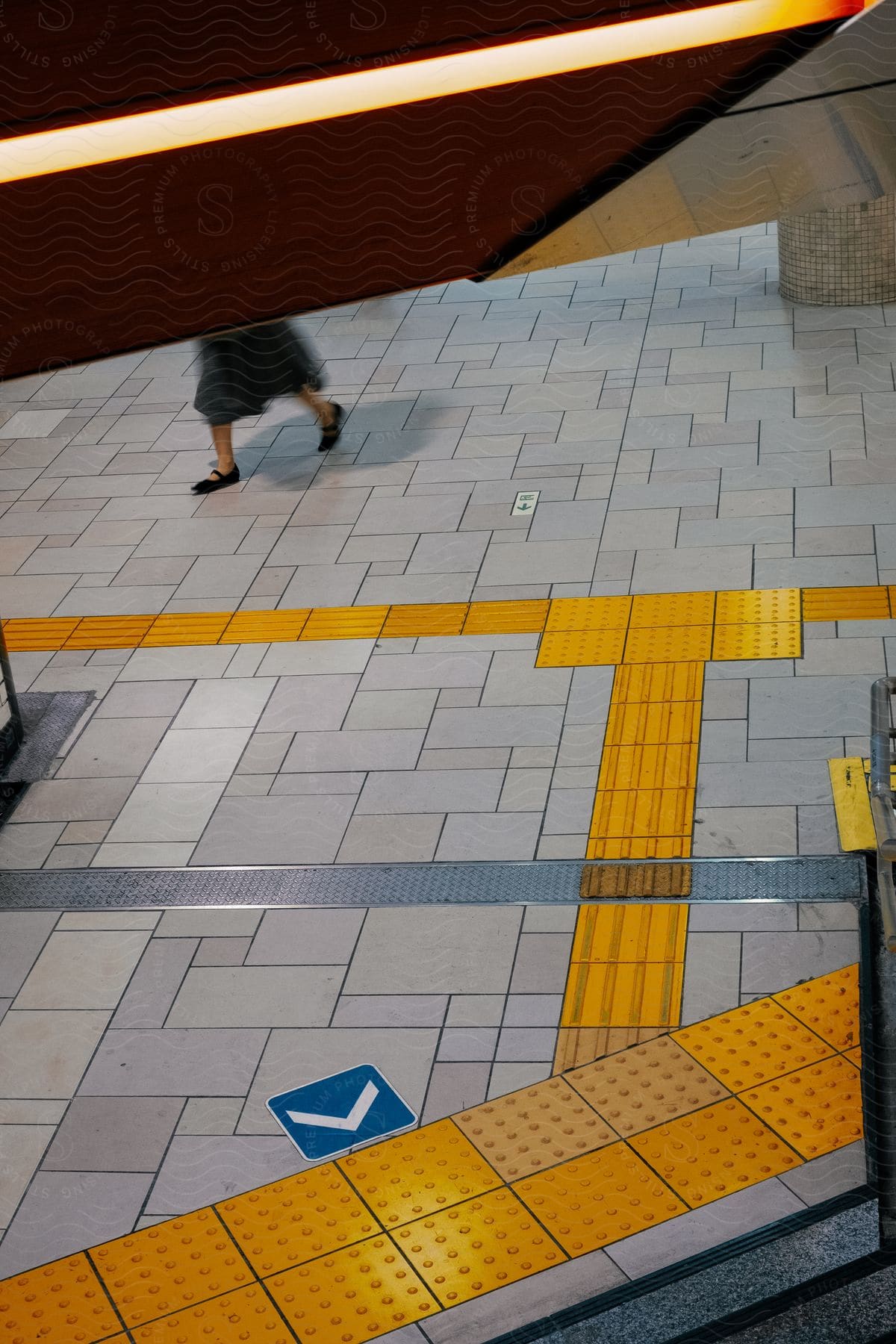 A woman walks on a train station platform with high heels