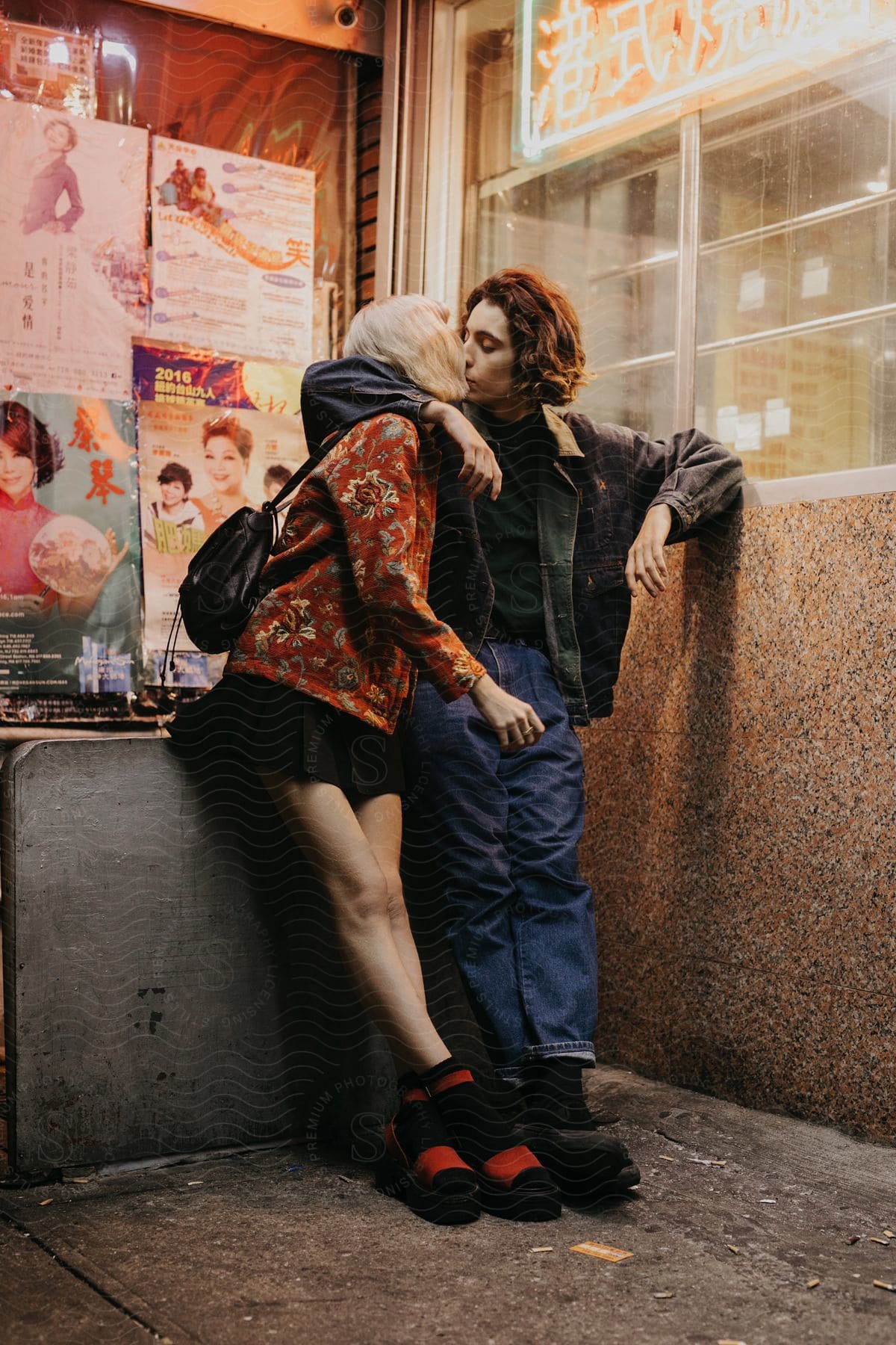 A romantic couple kissing under a building at night in brooklyn