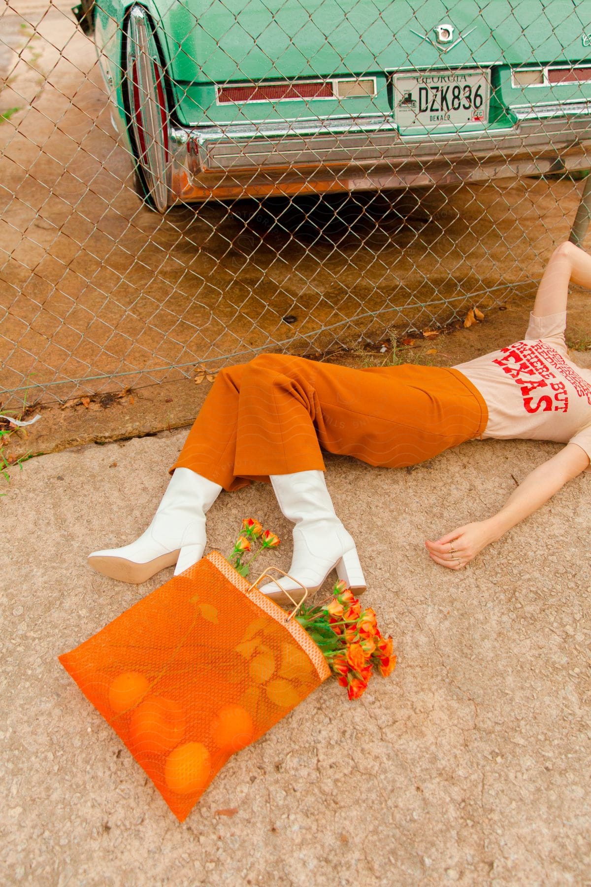Stock photo of woman lying down on the floor next to a bag of groceries