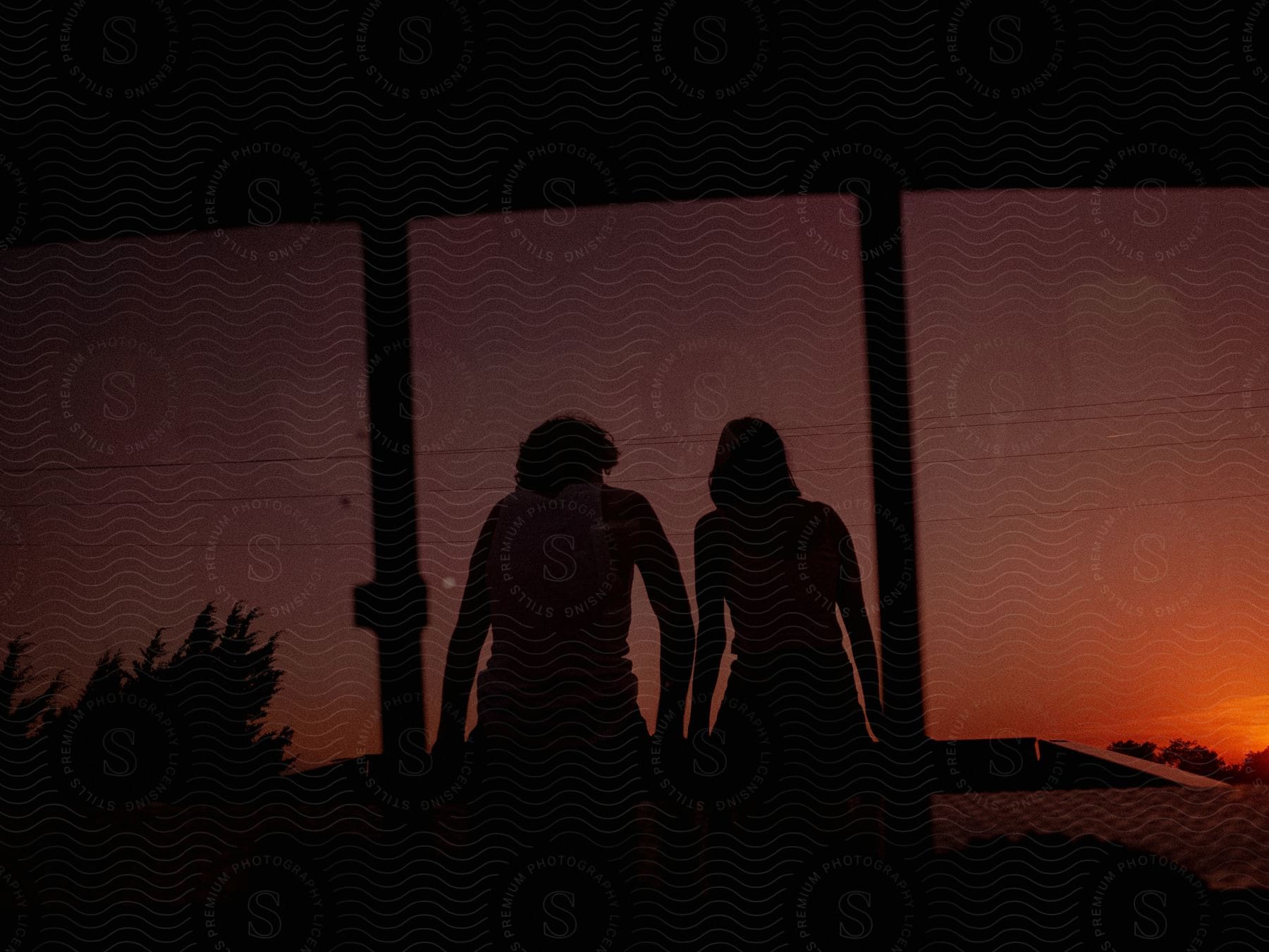 Man and woman silhouetted against the sunset sky