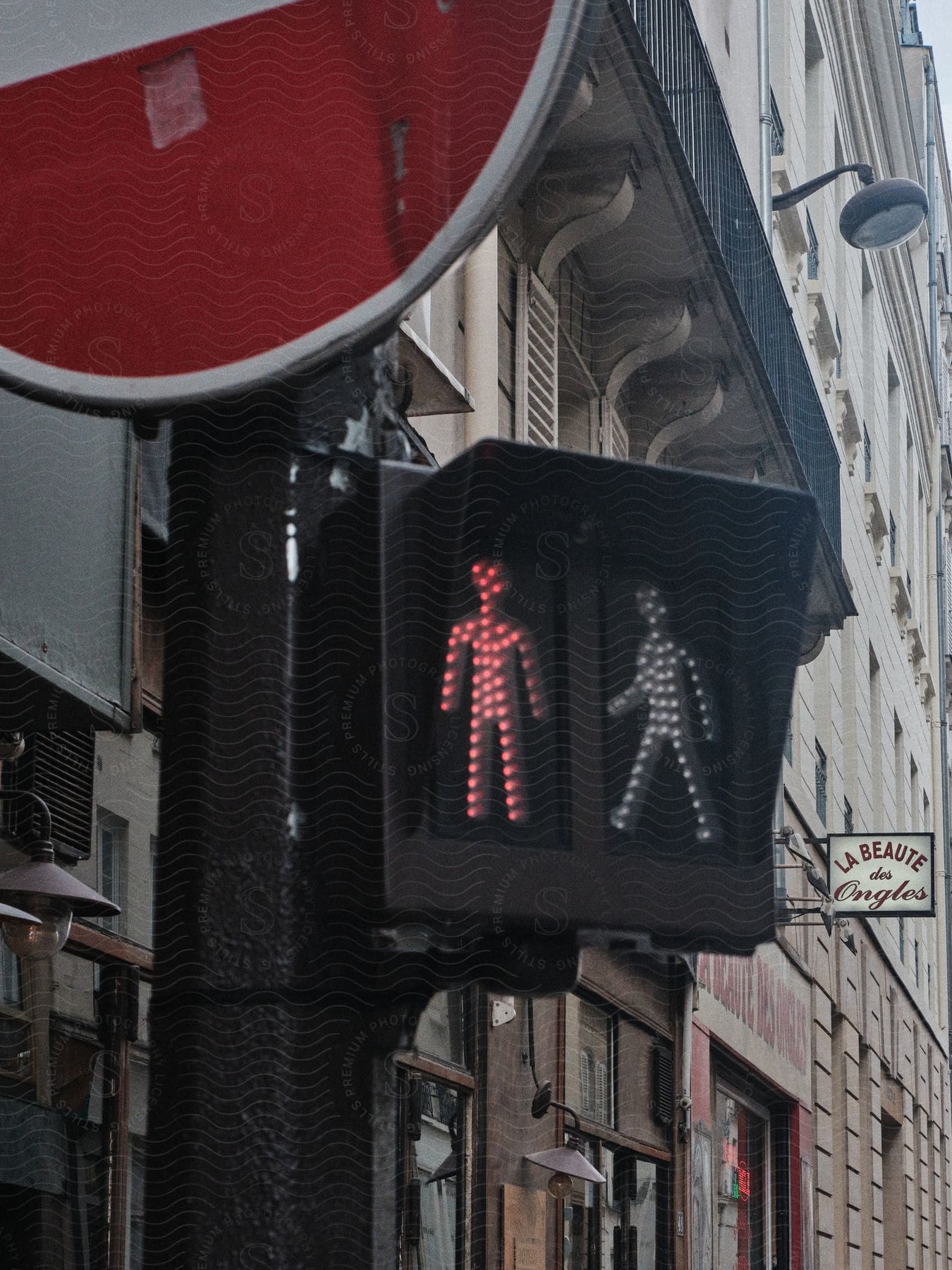 Red pedestrian traffic light in front of buildings in paris 23