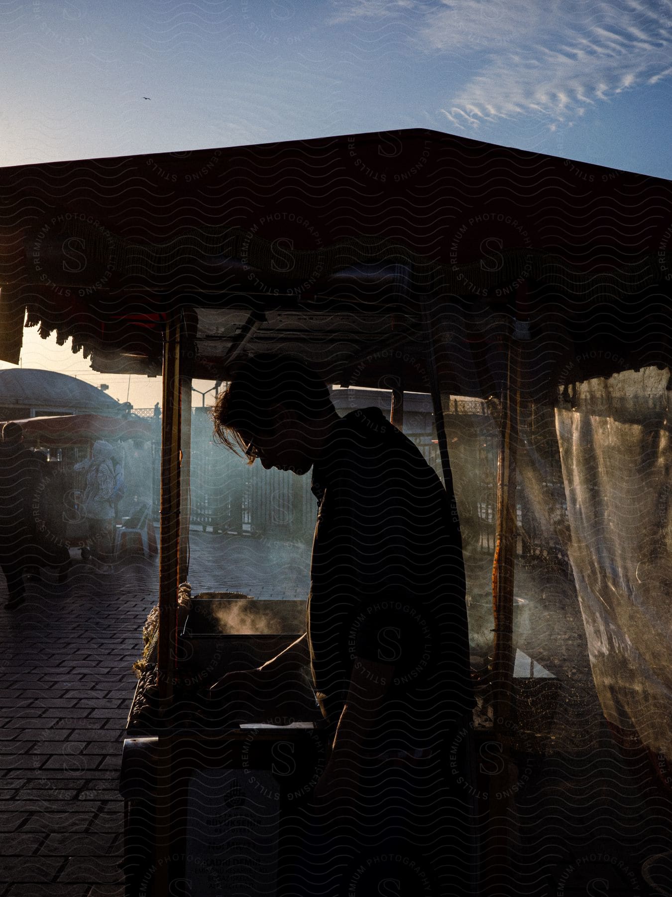 A man preparing food at a food stand in an urban public market