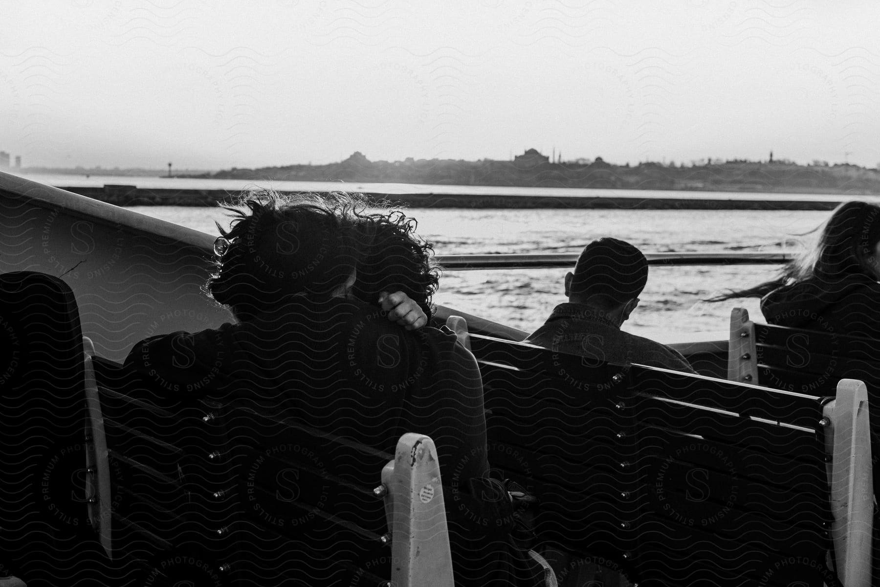 Unidentified gender couple hugging on a boat surrounded by other people