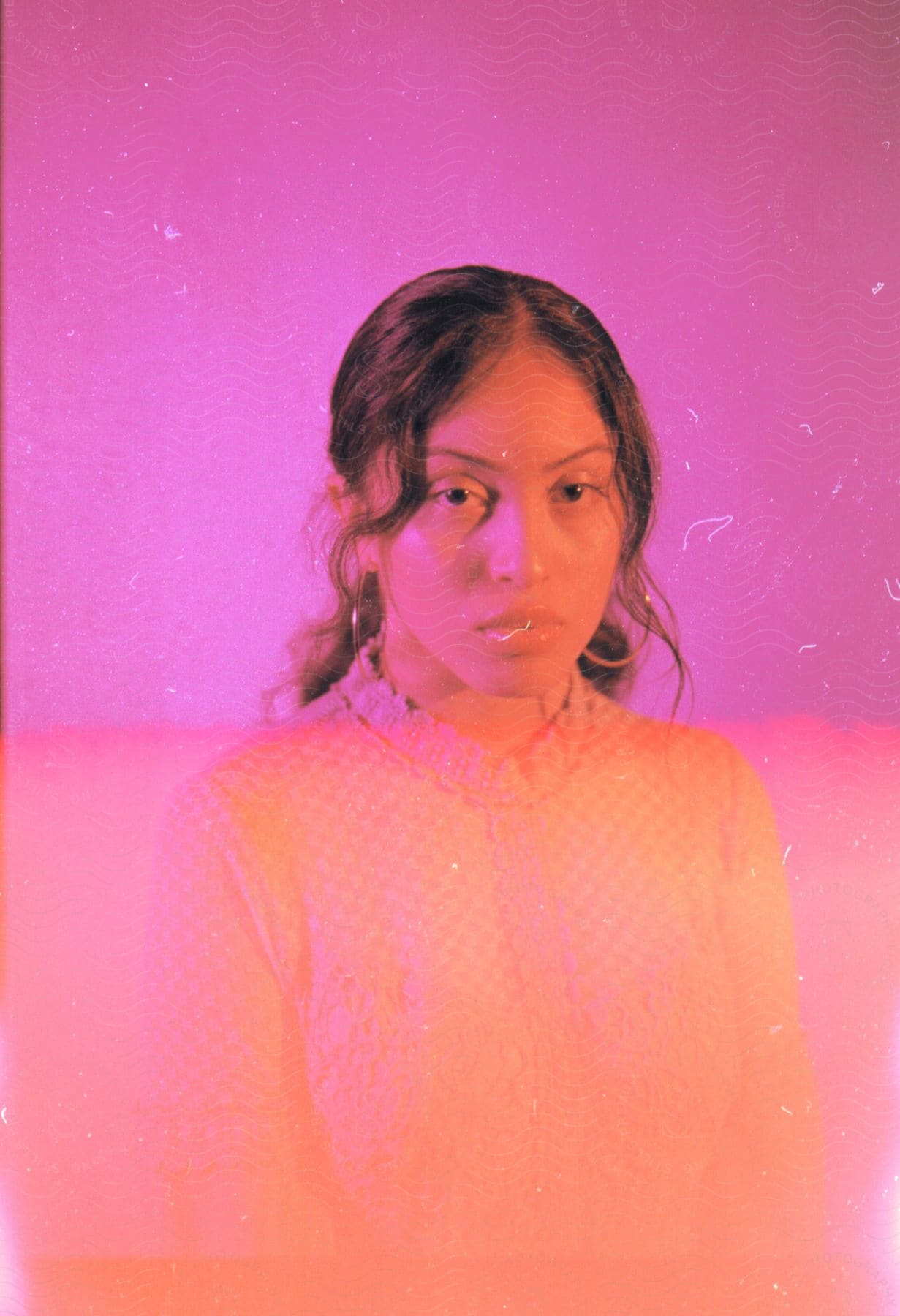 A portrait of a young woman in pink and orange lighting