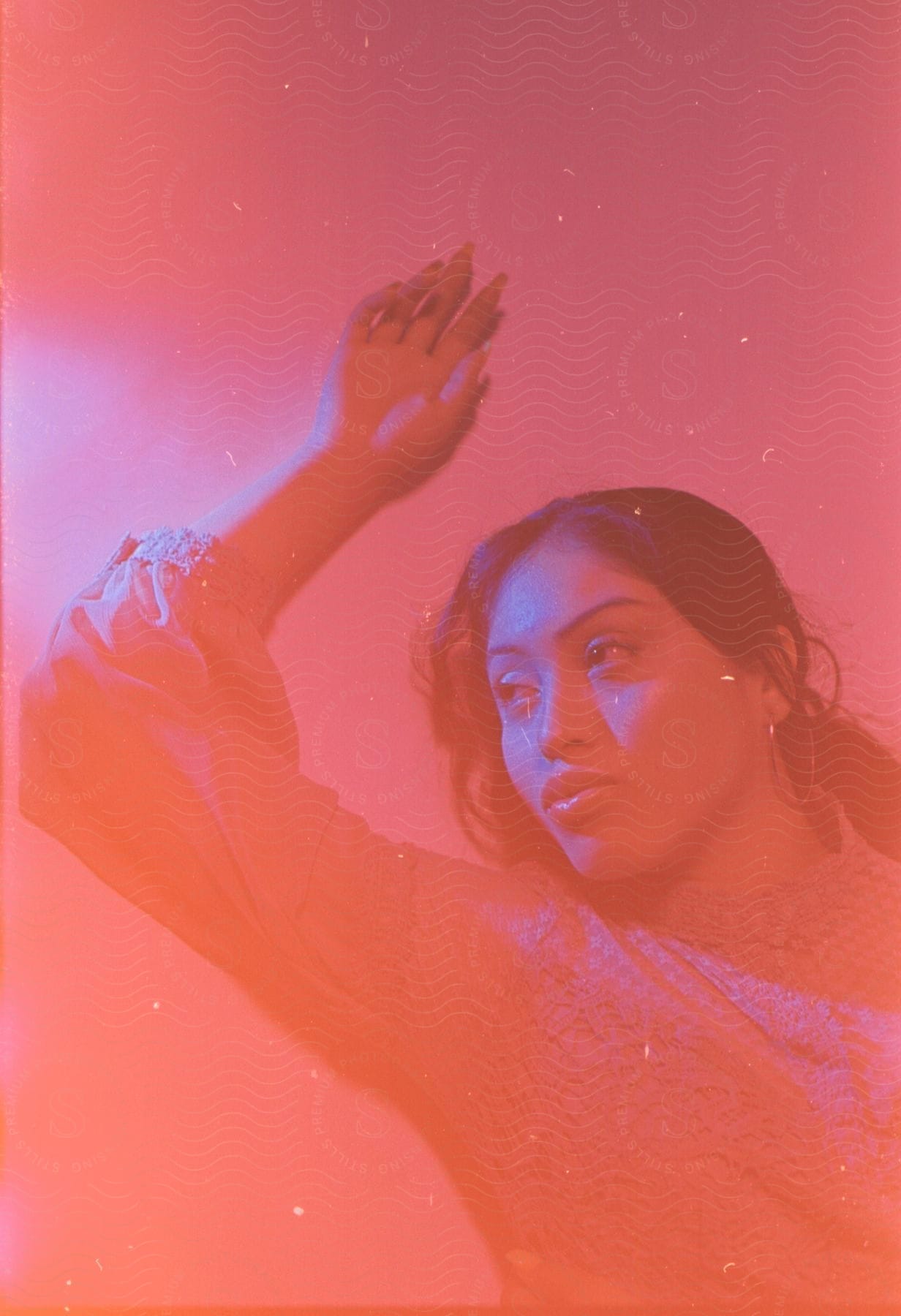 a pink hued light shines over a woman as she lies on the floor