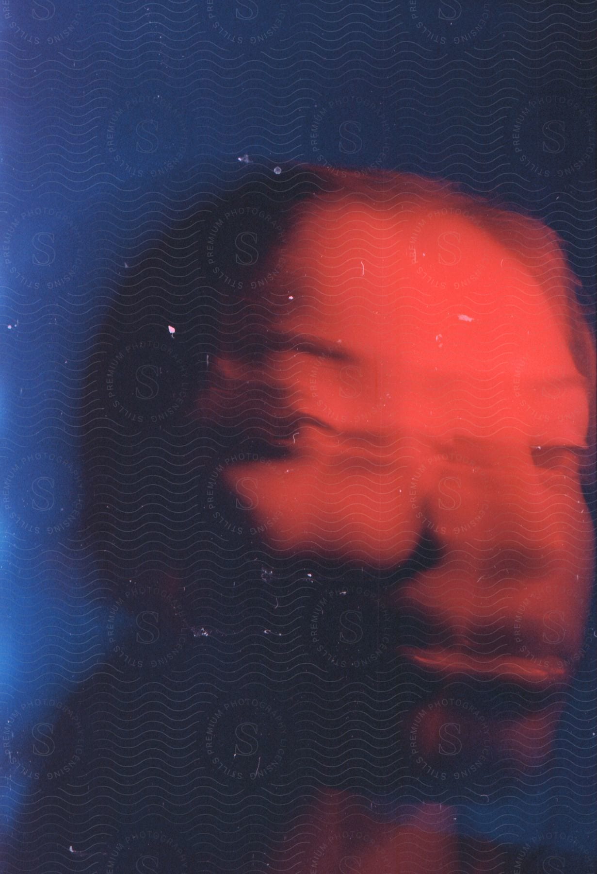 Distorted female face under red and blue lights with motion blur