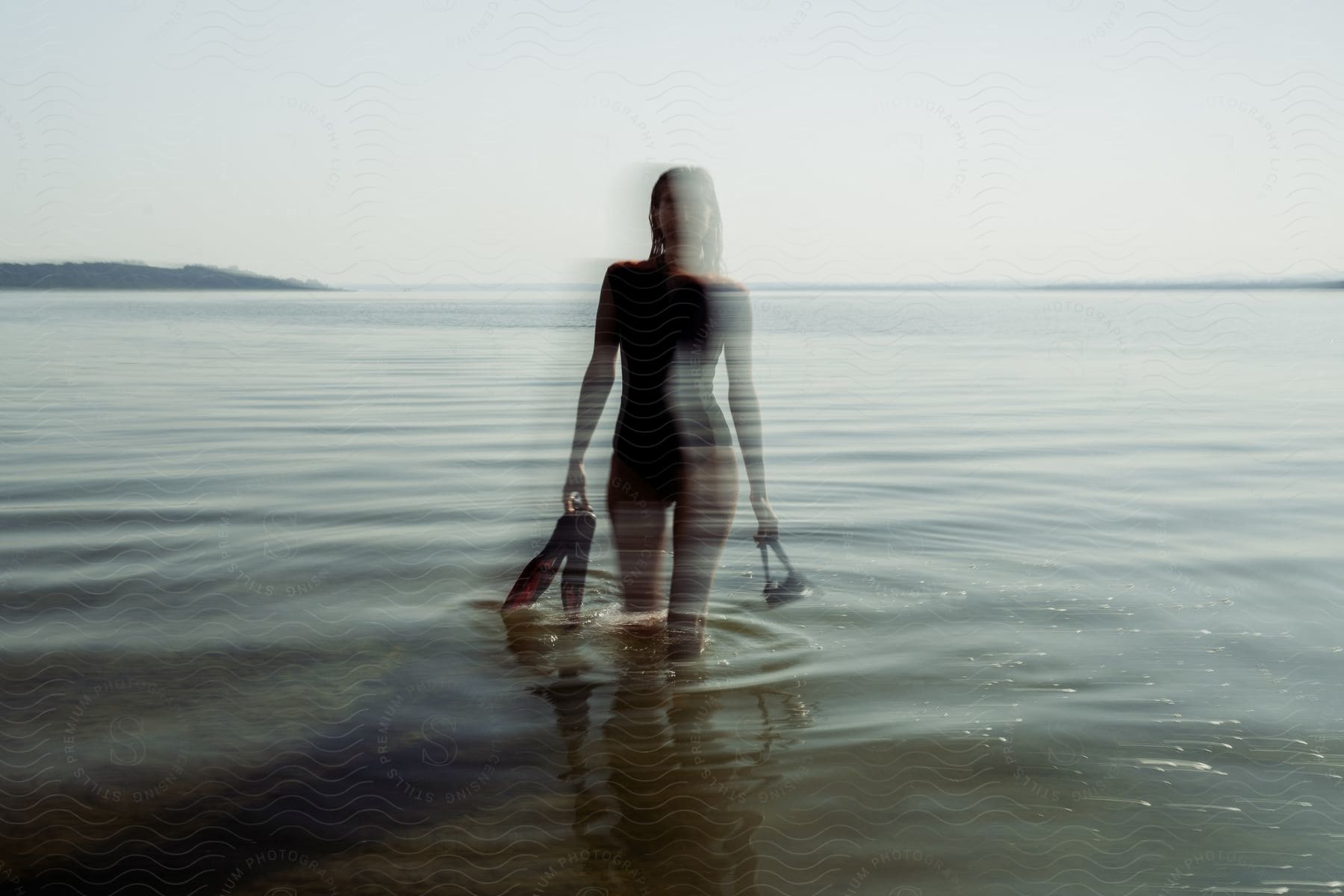 A woman standing in water outdoors with a silhouette effect