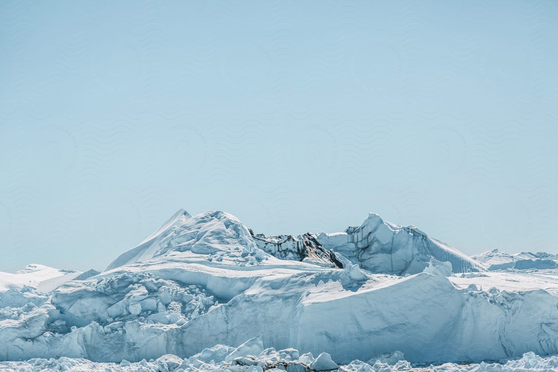 The arctic sun shines on polar ice caps under a clear sky in greenland