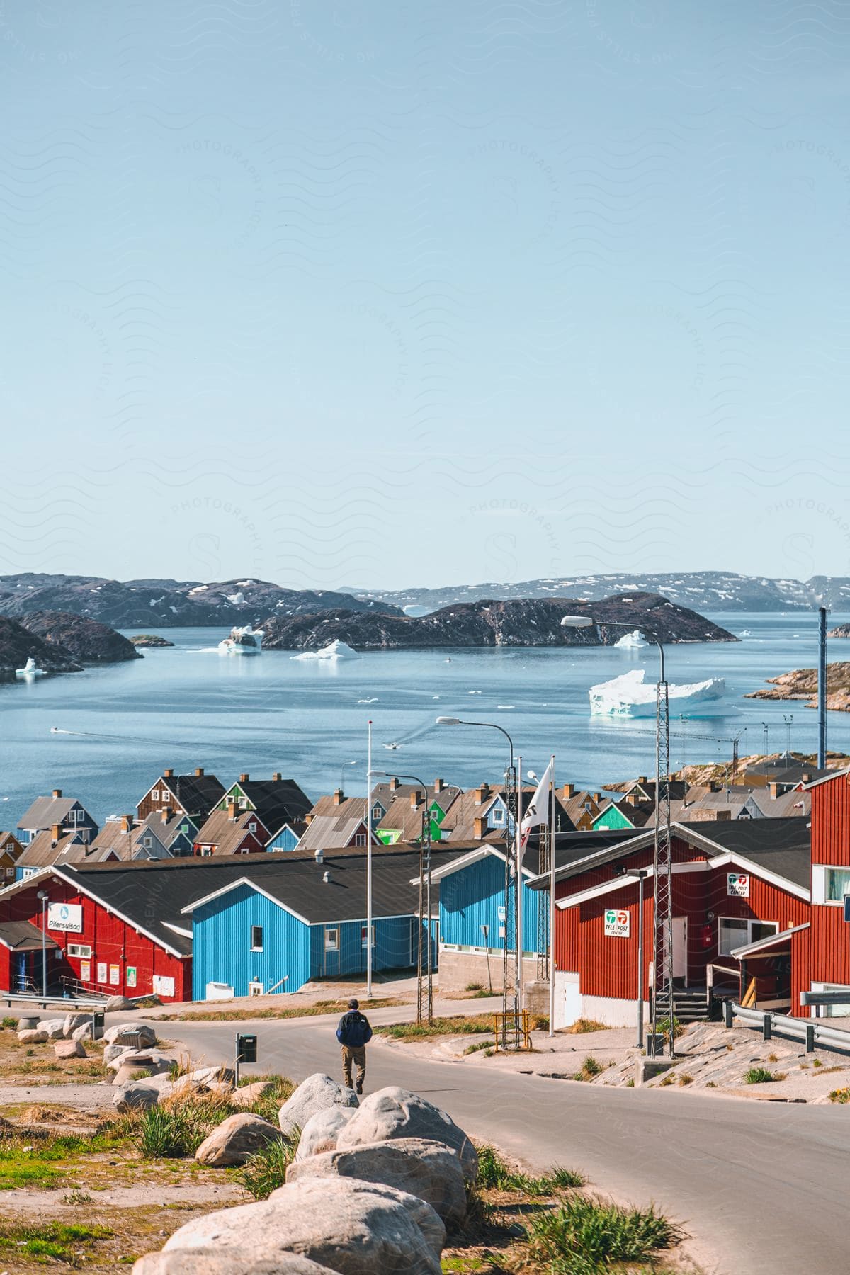 Coastal town with colorful houses sea icebergs and mountains on the horizon