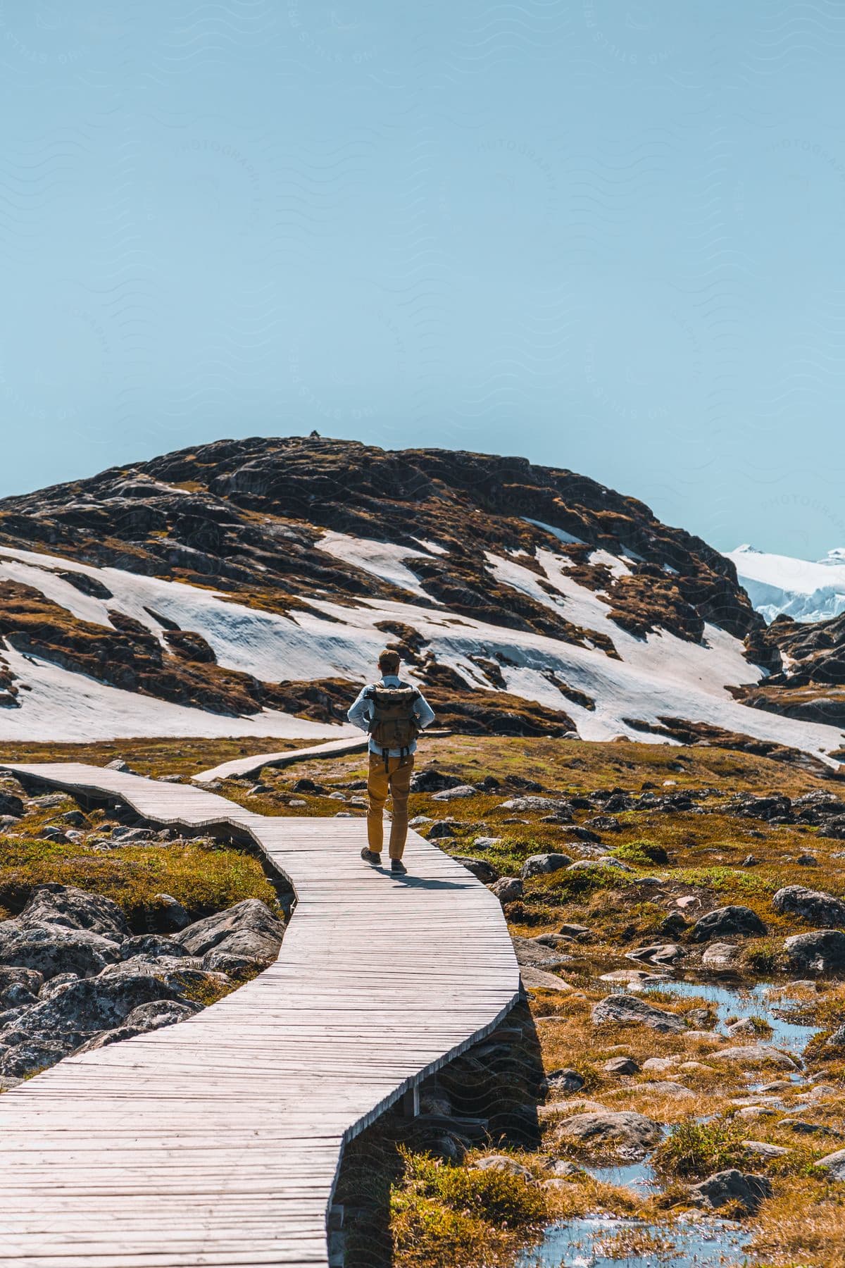 A man hiking in the snowcovered mountains of greenland