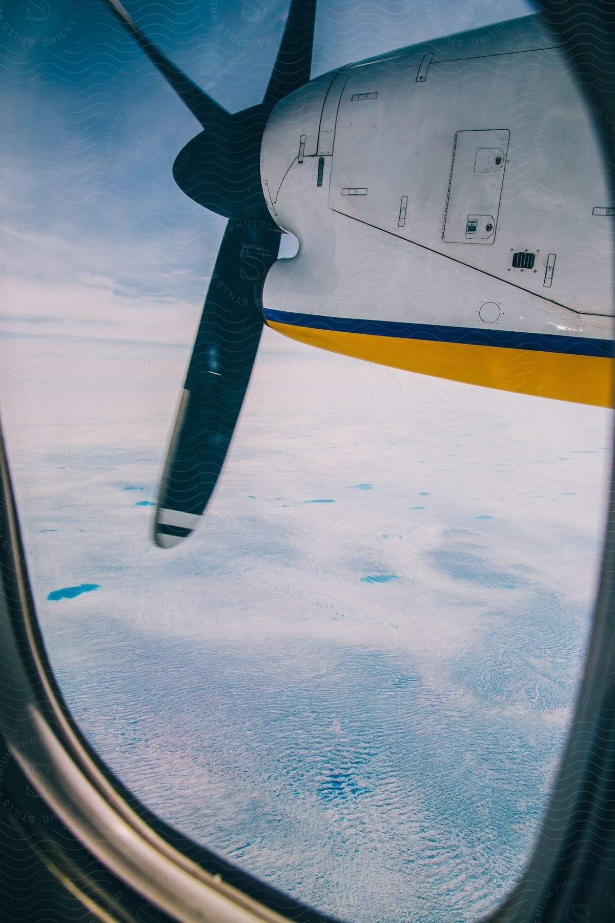 An airplane engine seen from a passenger window in flight over the ocean