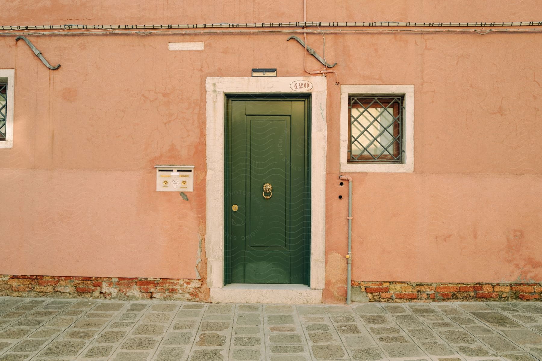 A wooden door with a mailbox in a corner of a building in venice