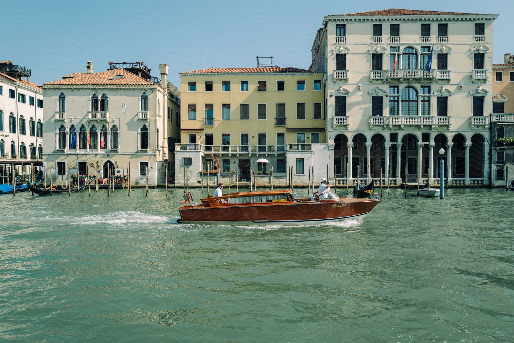 A boat passes by old buildings in a venice canal