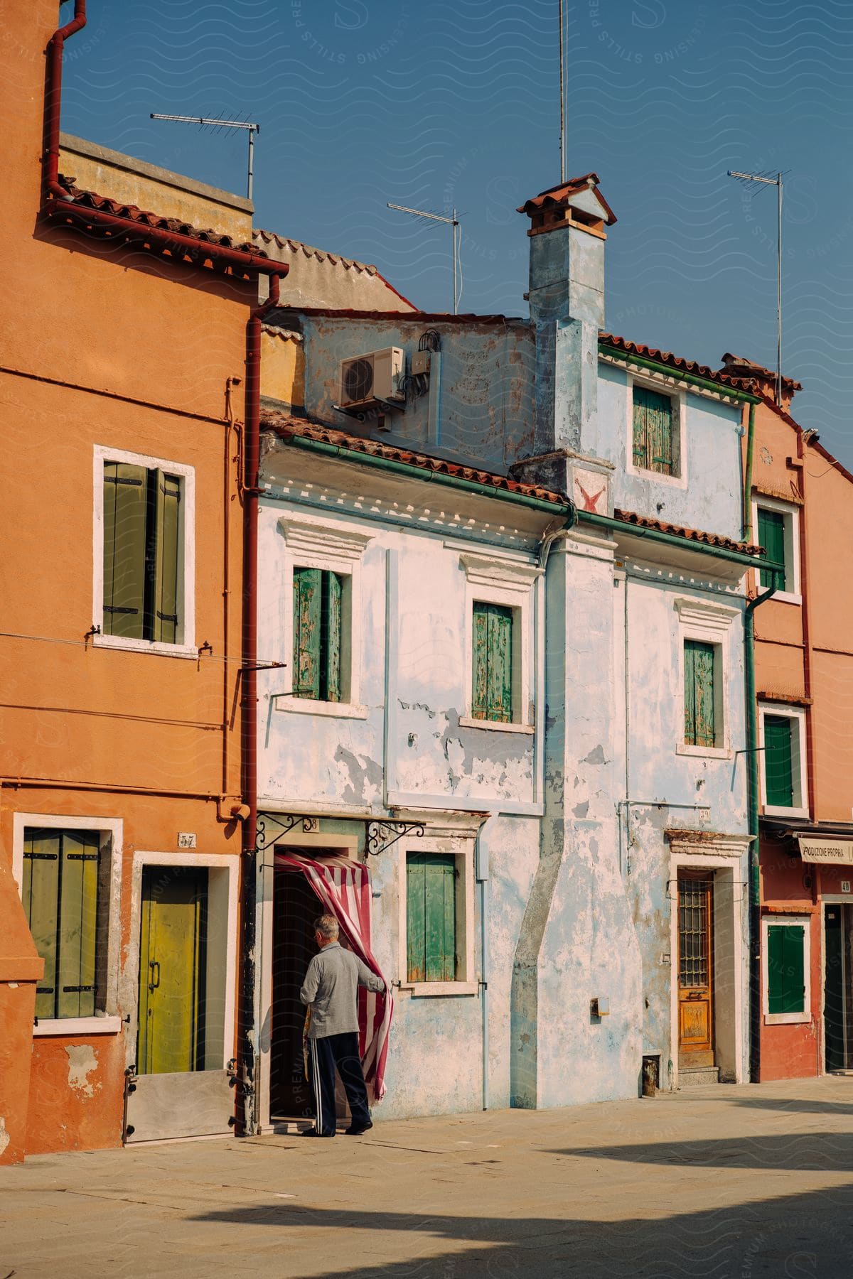 A man opens the curtain entrance to a building in venice