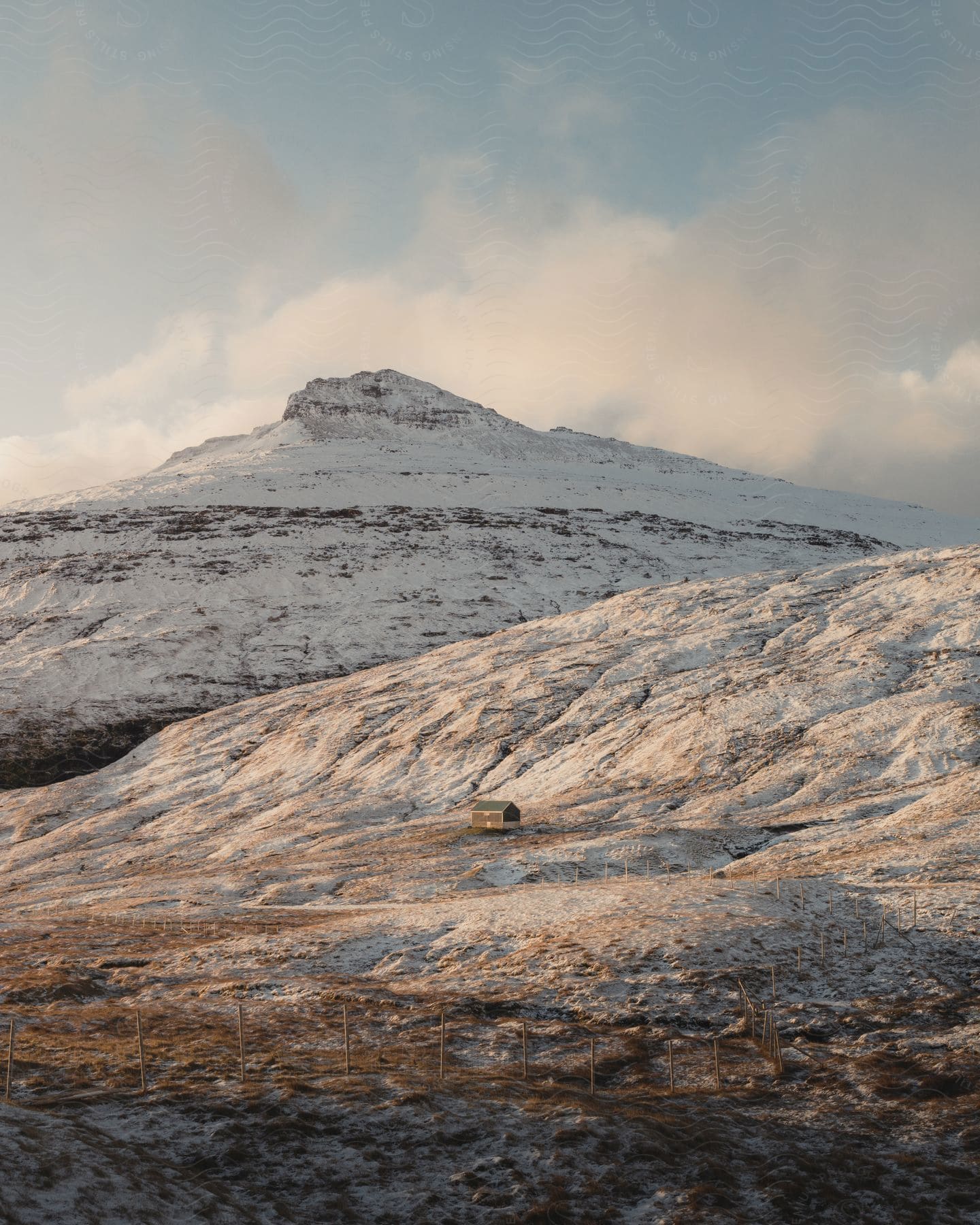 A mountainous landscape with snowy peaks and cloudy sky