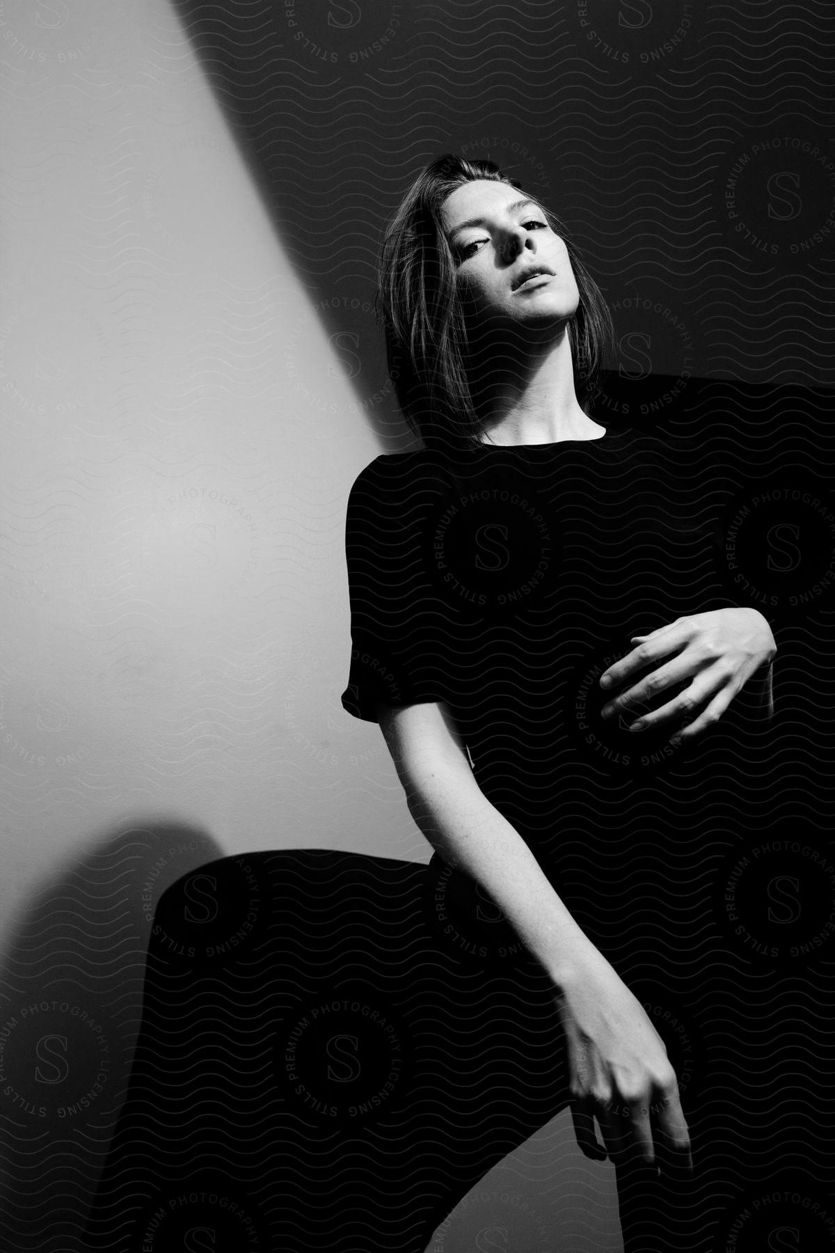 Woman standing in a black dress posing for a black and white portrait