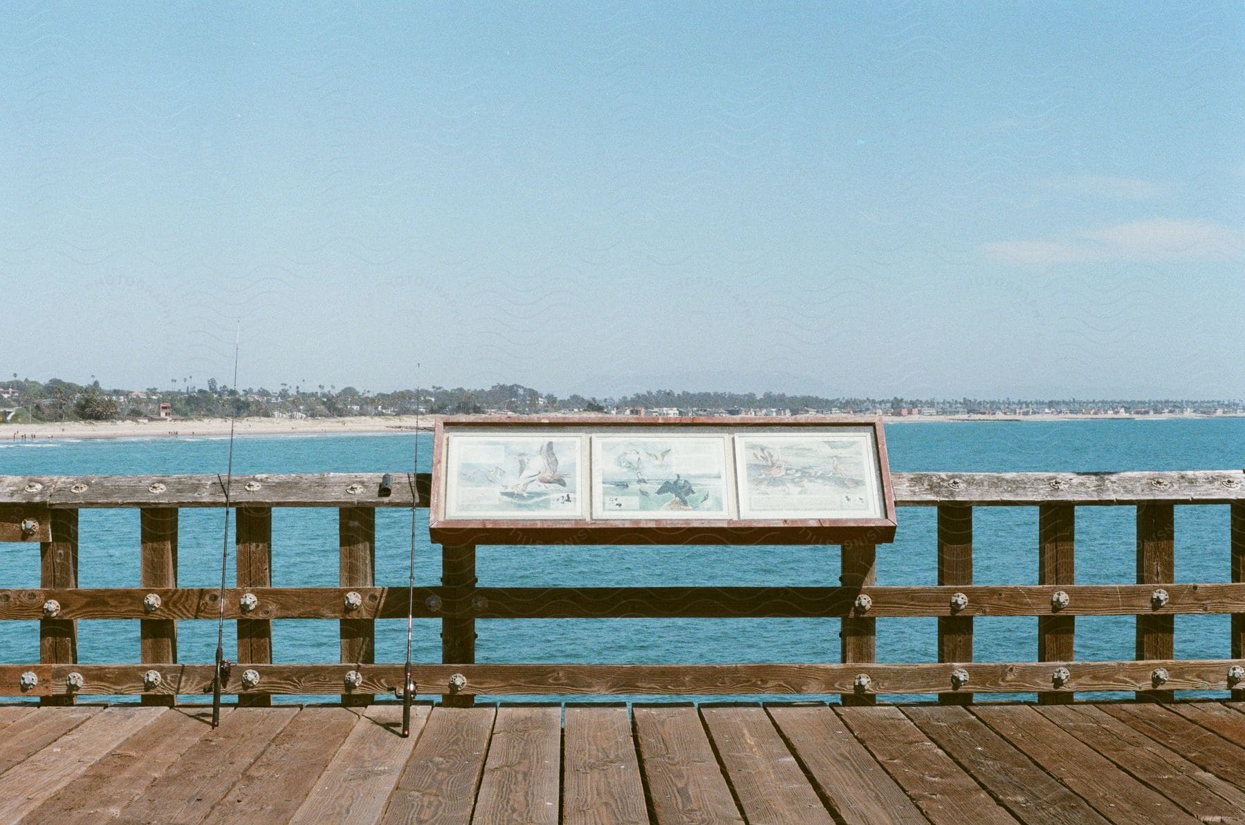 A serene view of a lake with a wooden pier and a distant tree