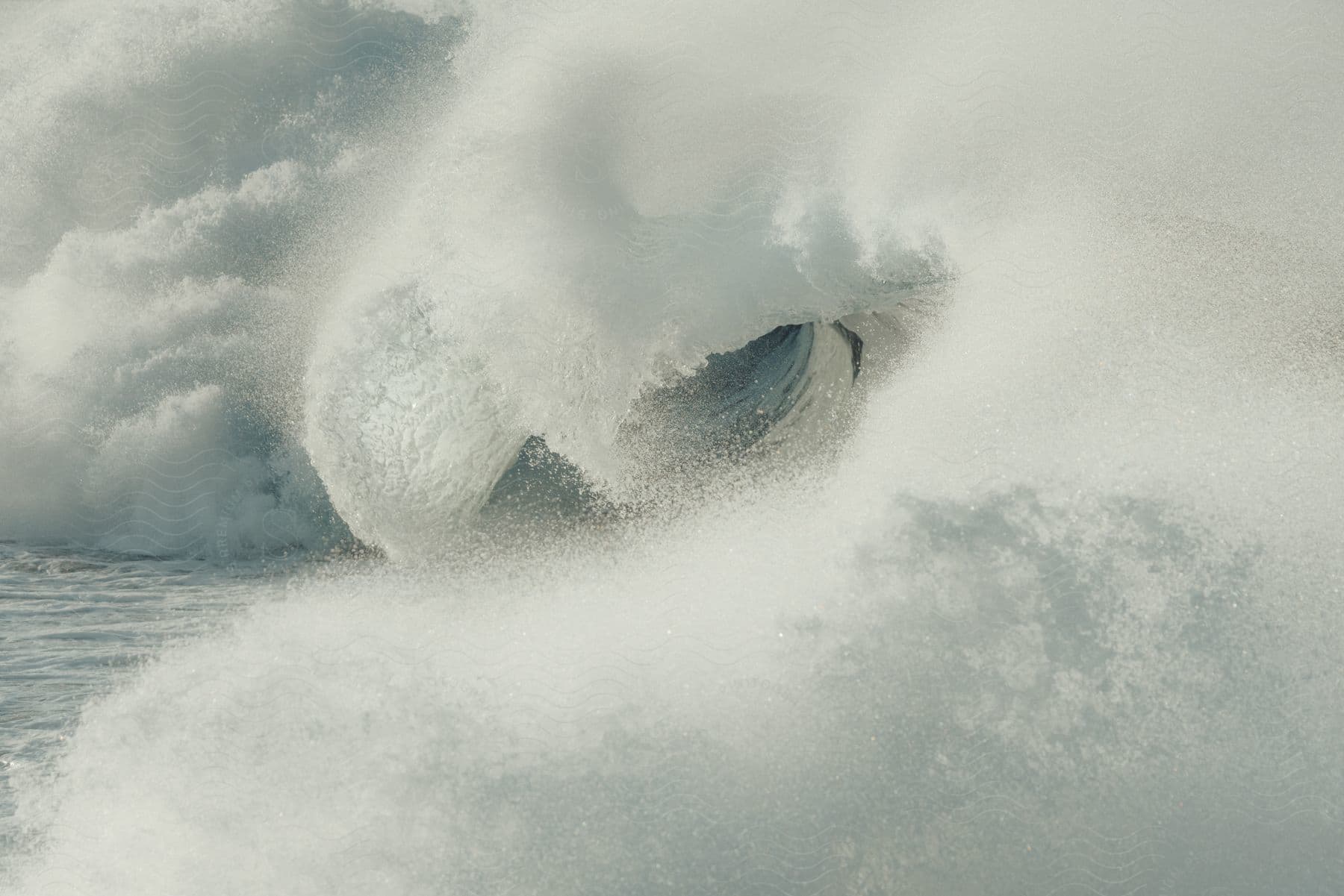 A swirling tornado distorts the water surface in the middle of the ocean