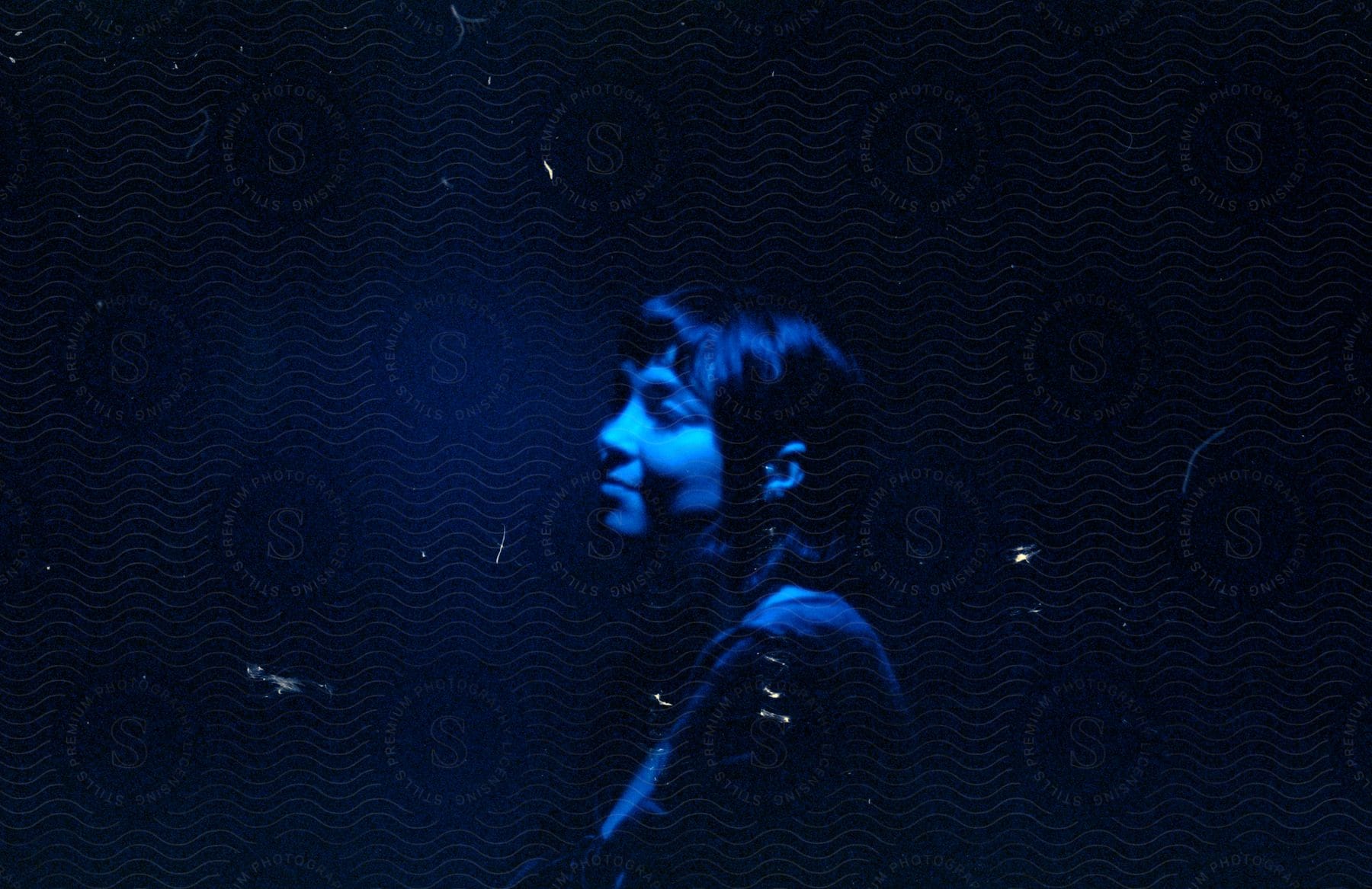 Woman smiling outdoors under blue lights at night time