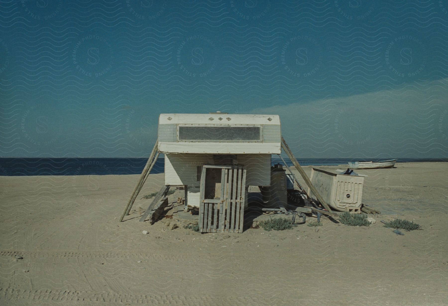 Caravan propped up with poles on the beach