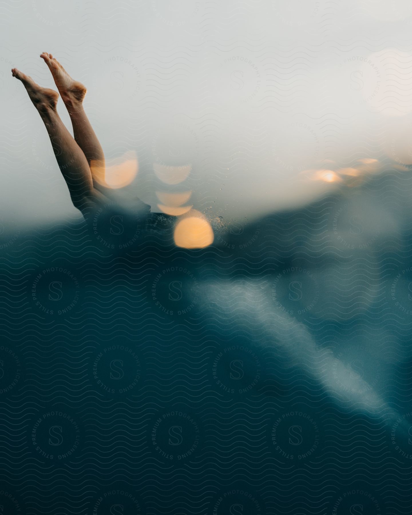 A persons feet diving into the water