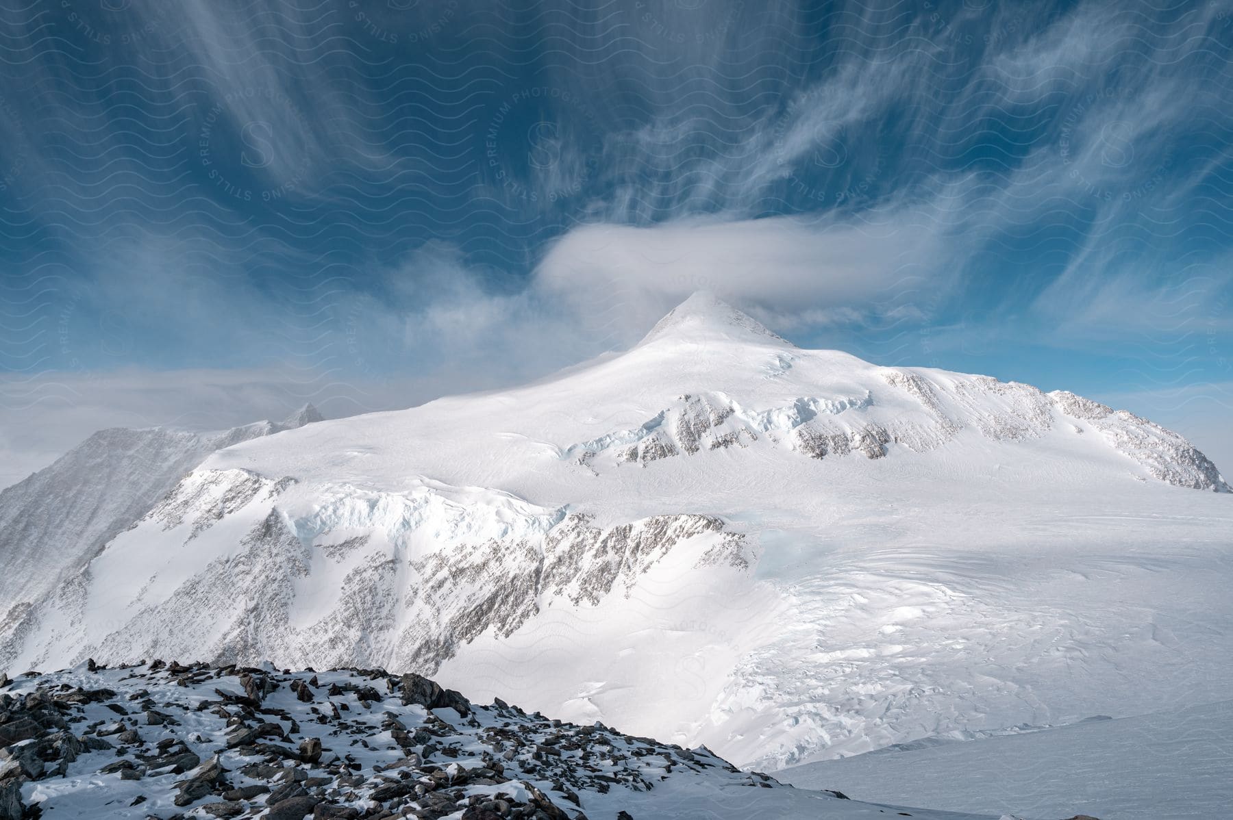 A snowcovered mountain with a blue sky and a few clouds