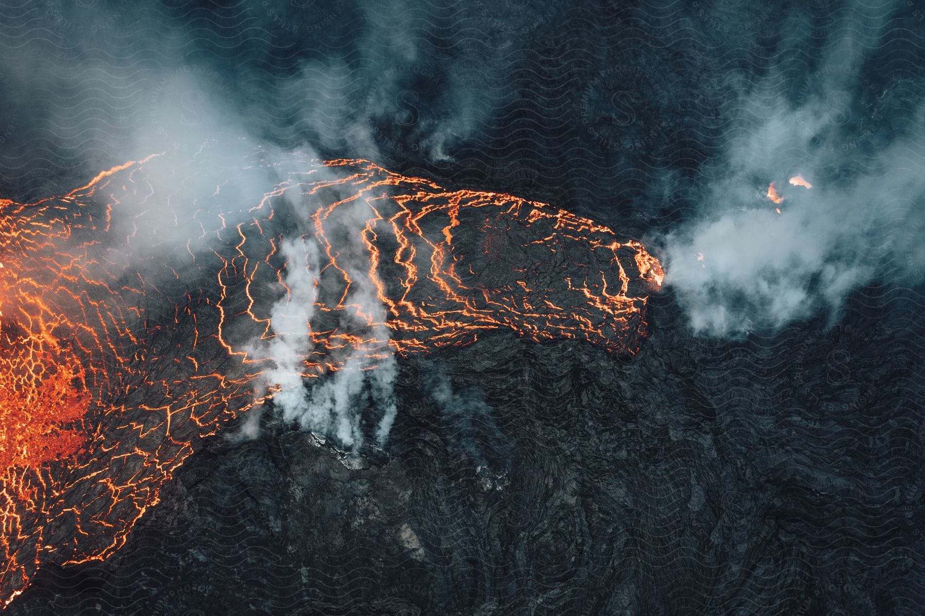 Smoke rises as a volcano erupts and hot magma flows in the darkness