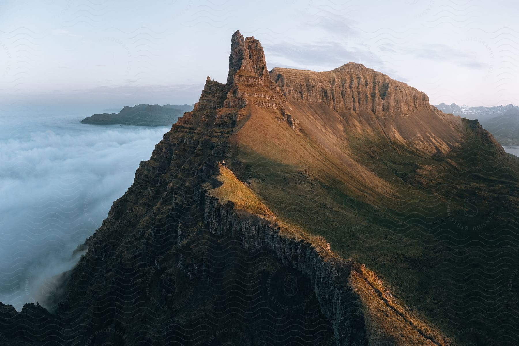 Rock formations stand on an escarpment high in the clouds along the coast