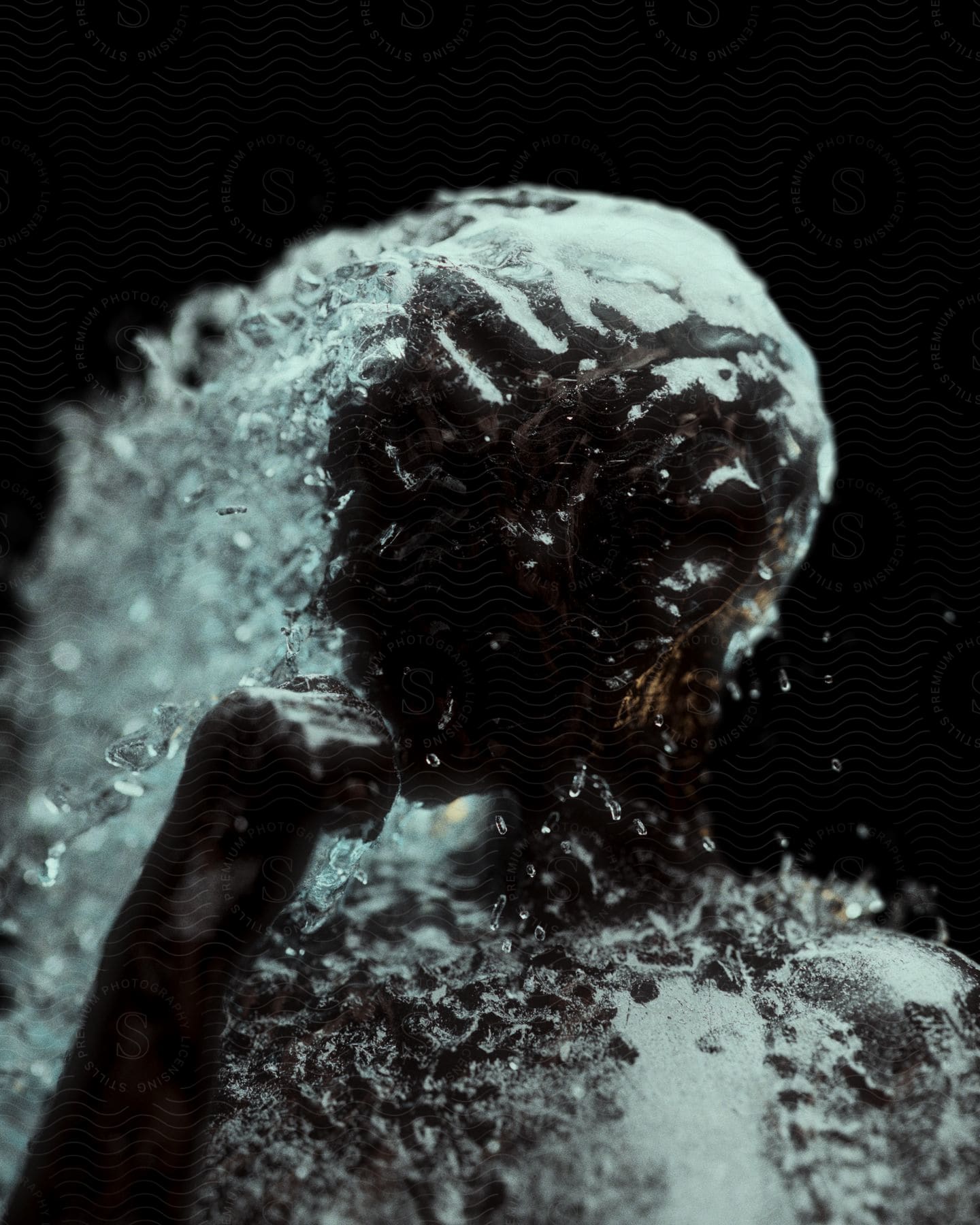 Water flowing over a human sculpture with a raised fist