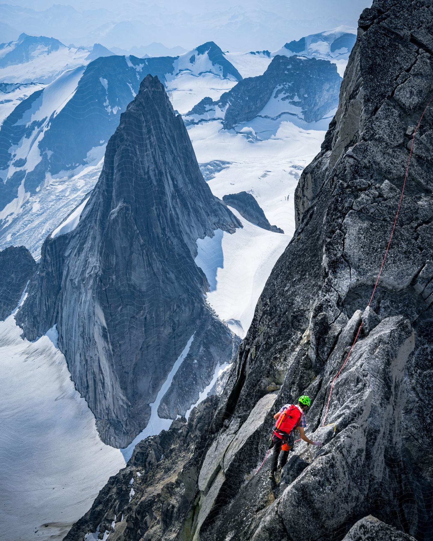 A man climbing the side of a mountain in bugaboos canmore alberta canada