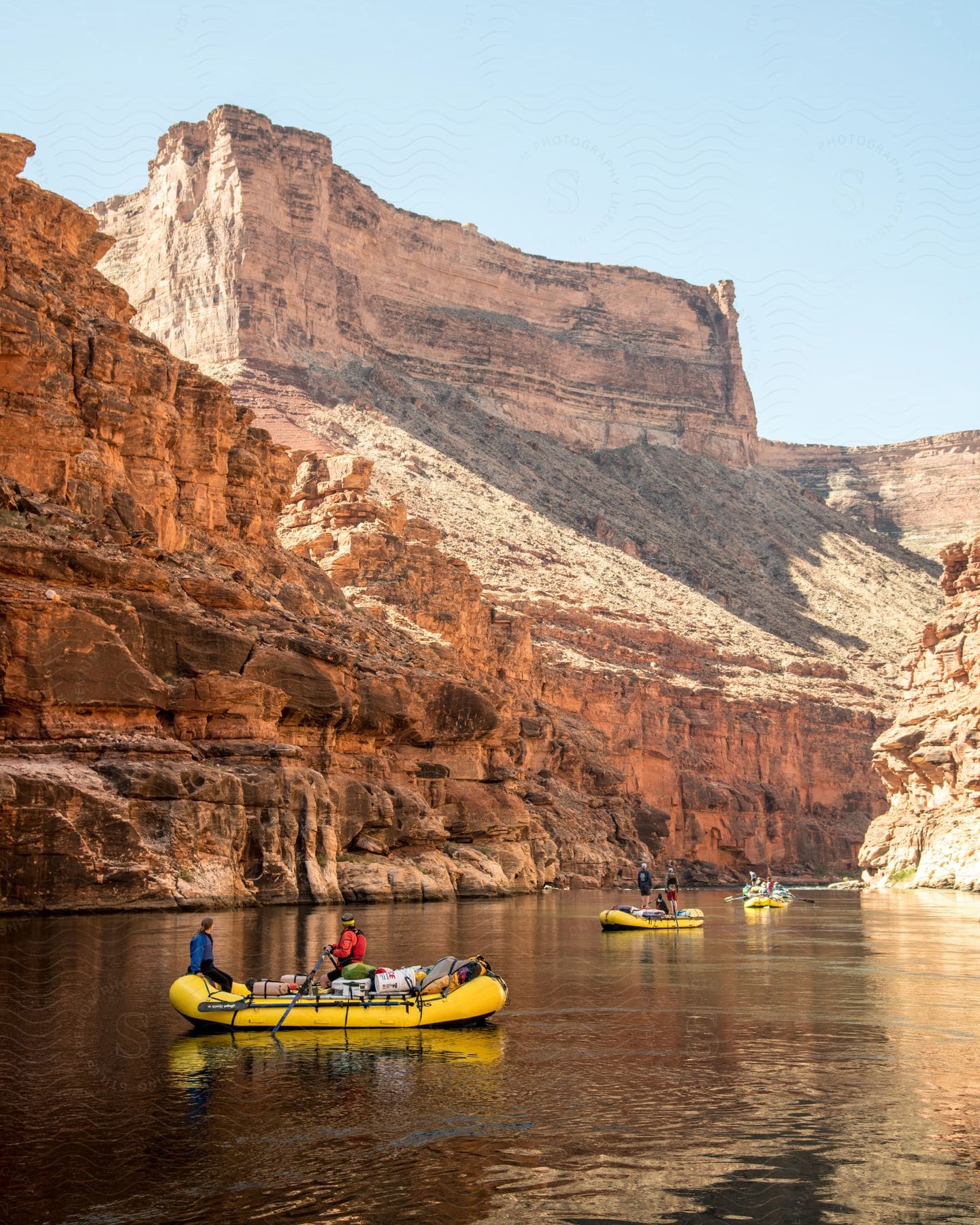 A Group Of People On Boats In A Lake And Mountain Landscape