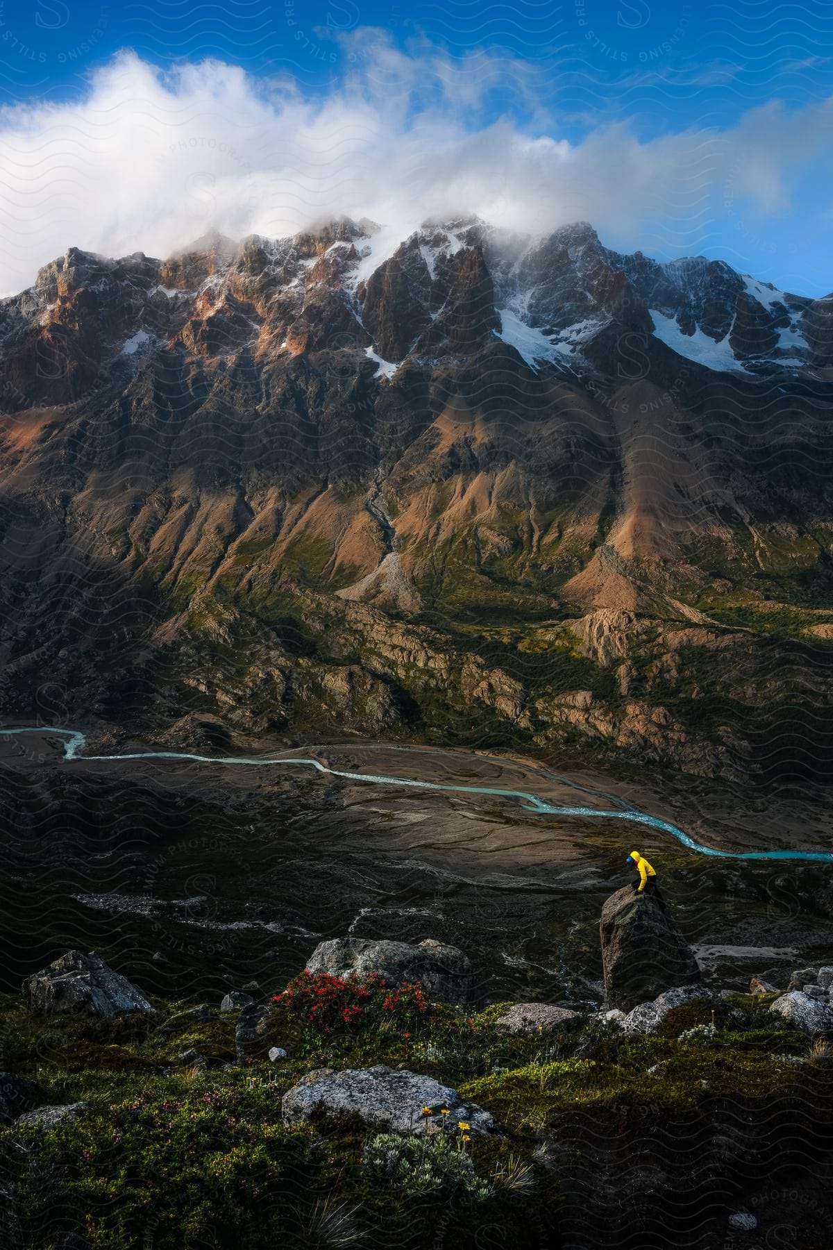 A man stands on a rock near a river below a canyon in el chalten patagonia