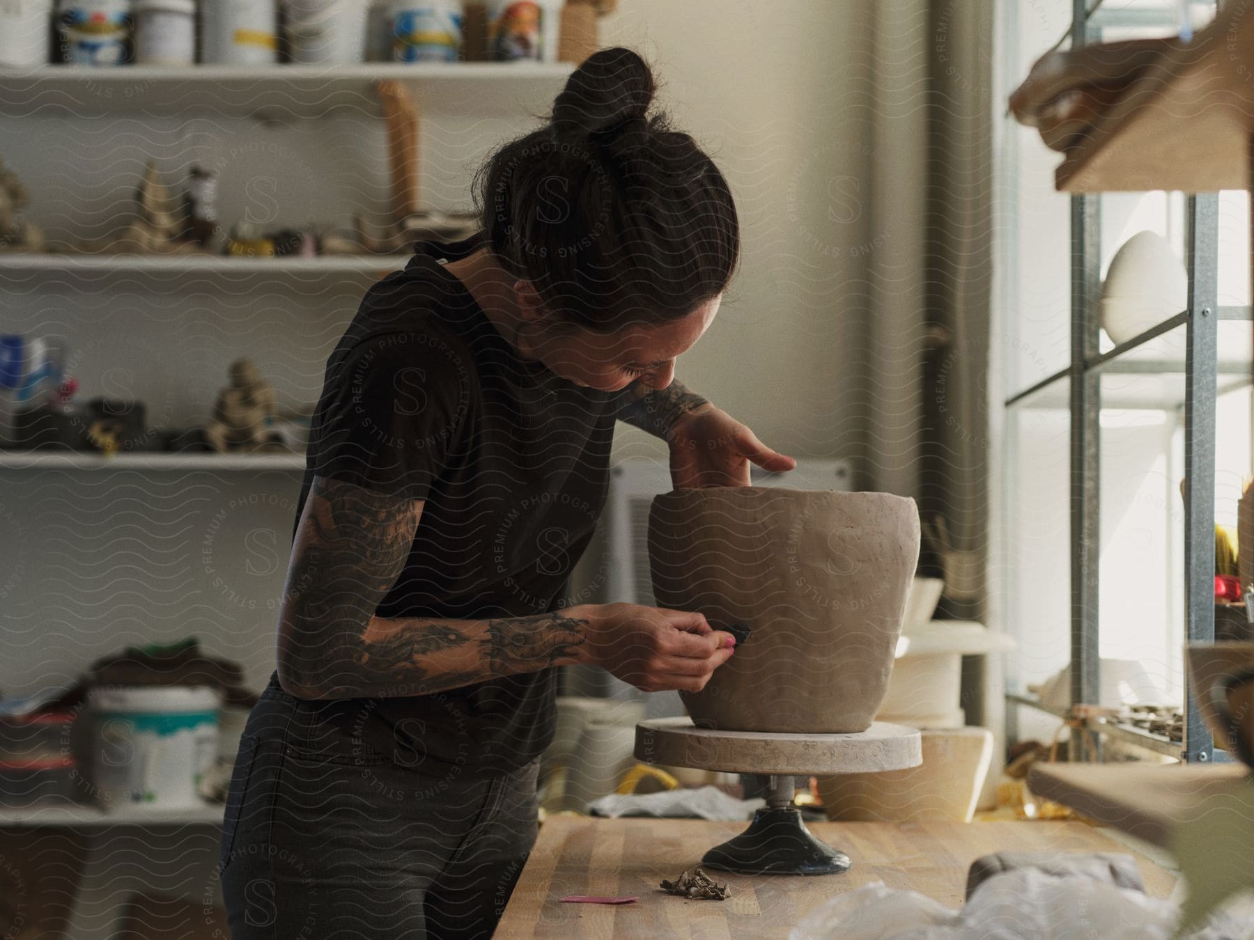 A woman working on a clay pot in an art shop